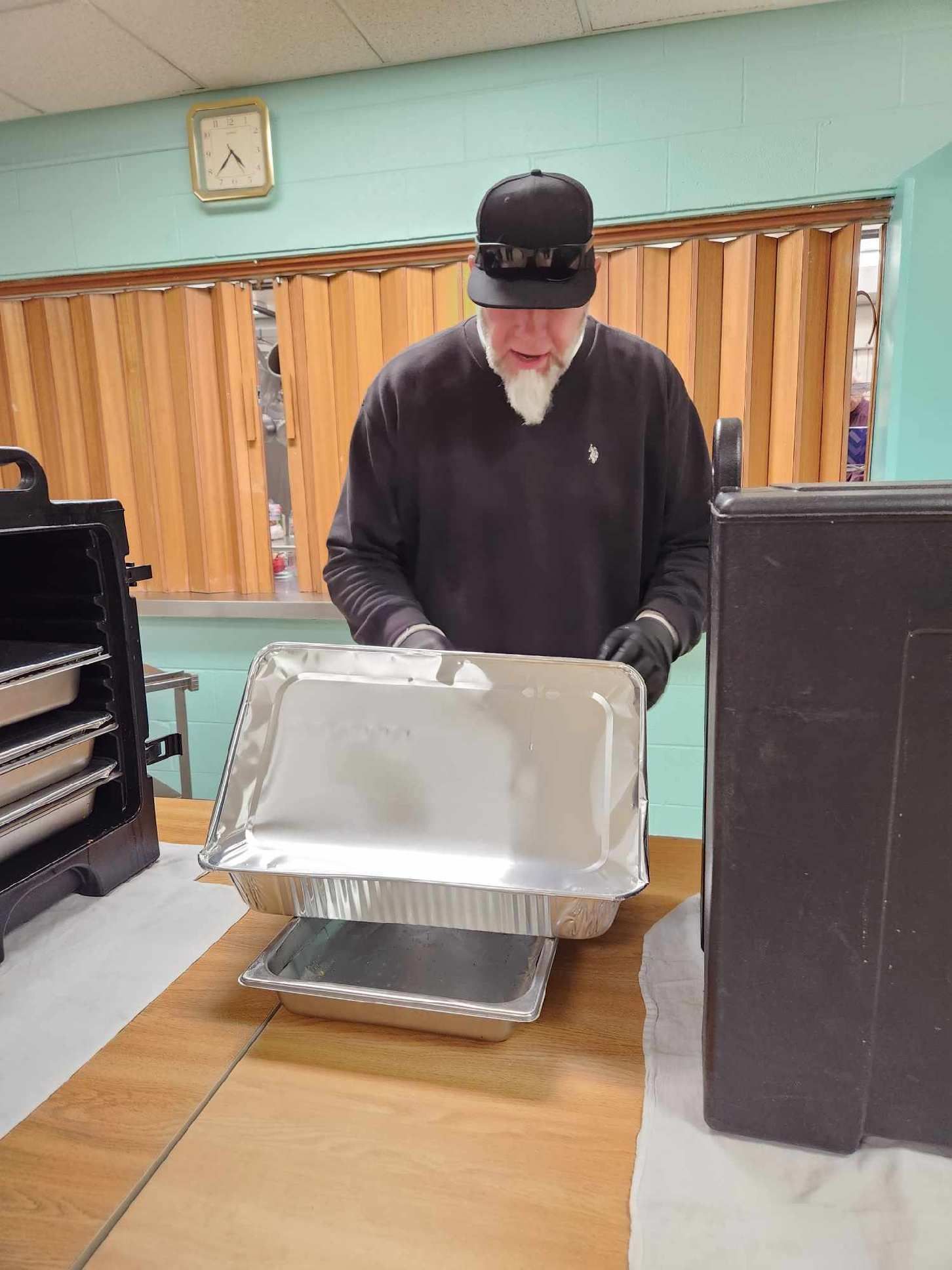 A man is standing at a table holding a tray of food.