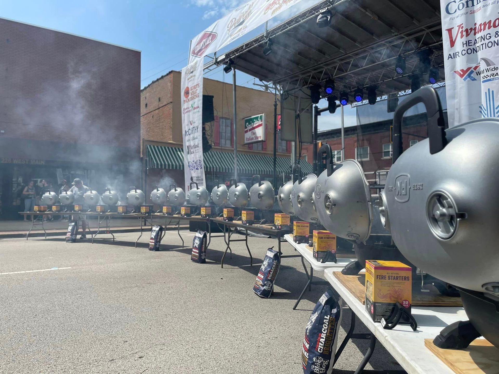 A row of grills are lined up on a table in front of a stage.
