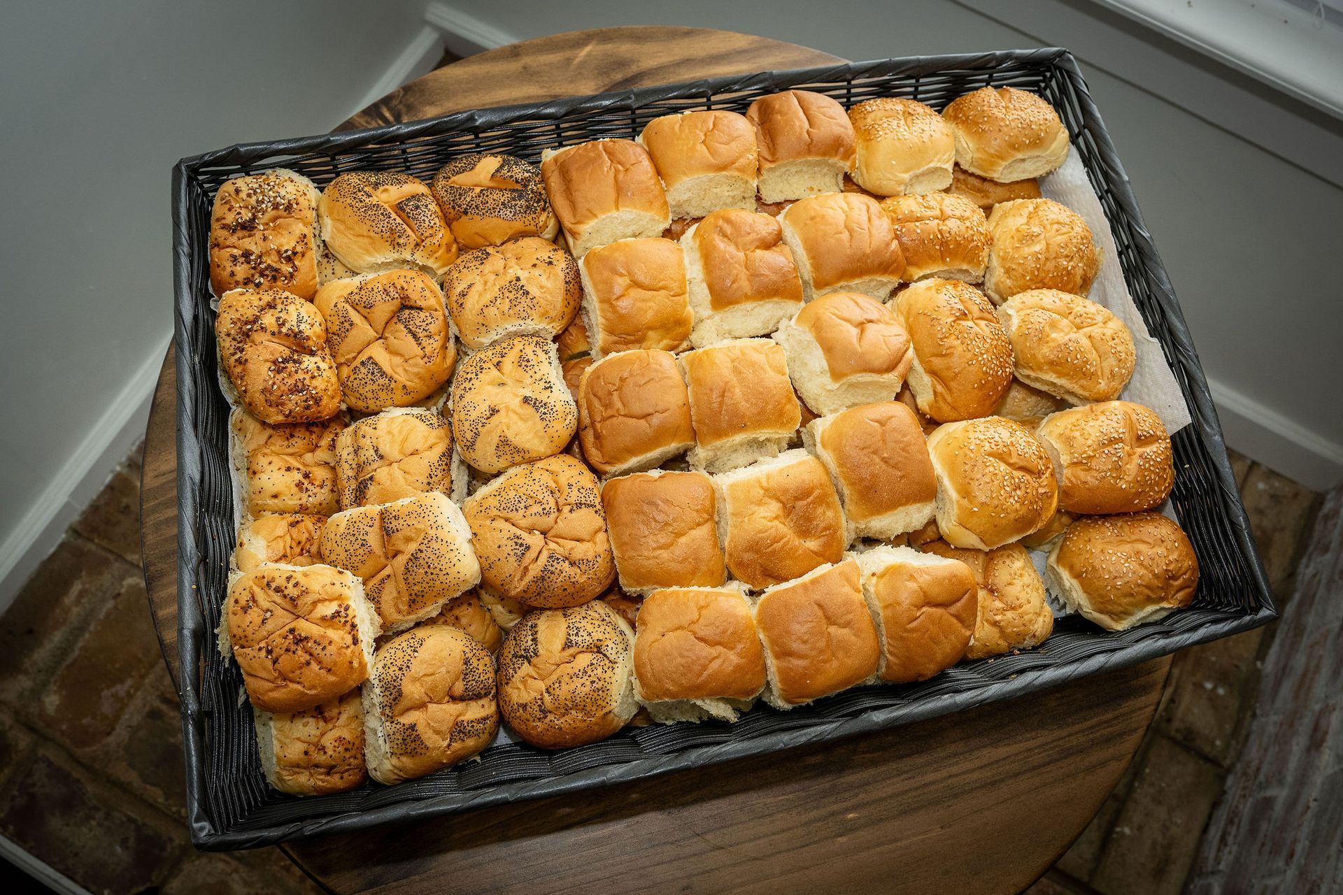 A tray of sandwiches is sitting on a wooden table.