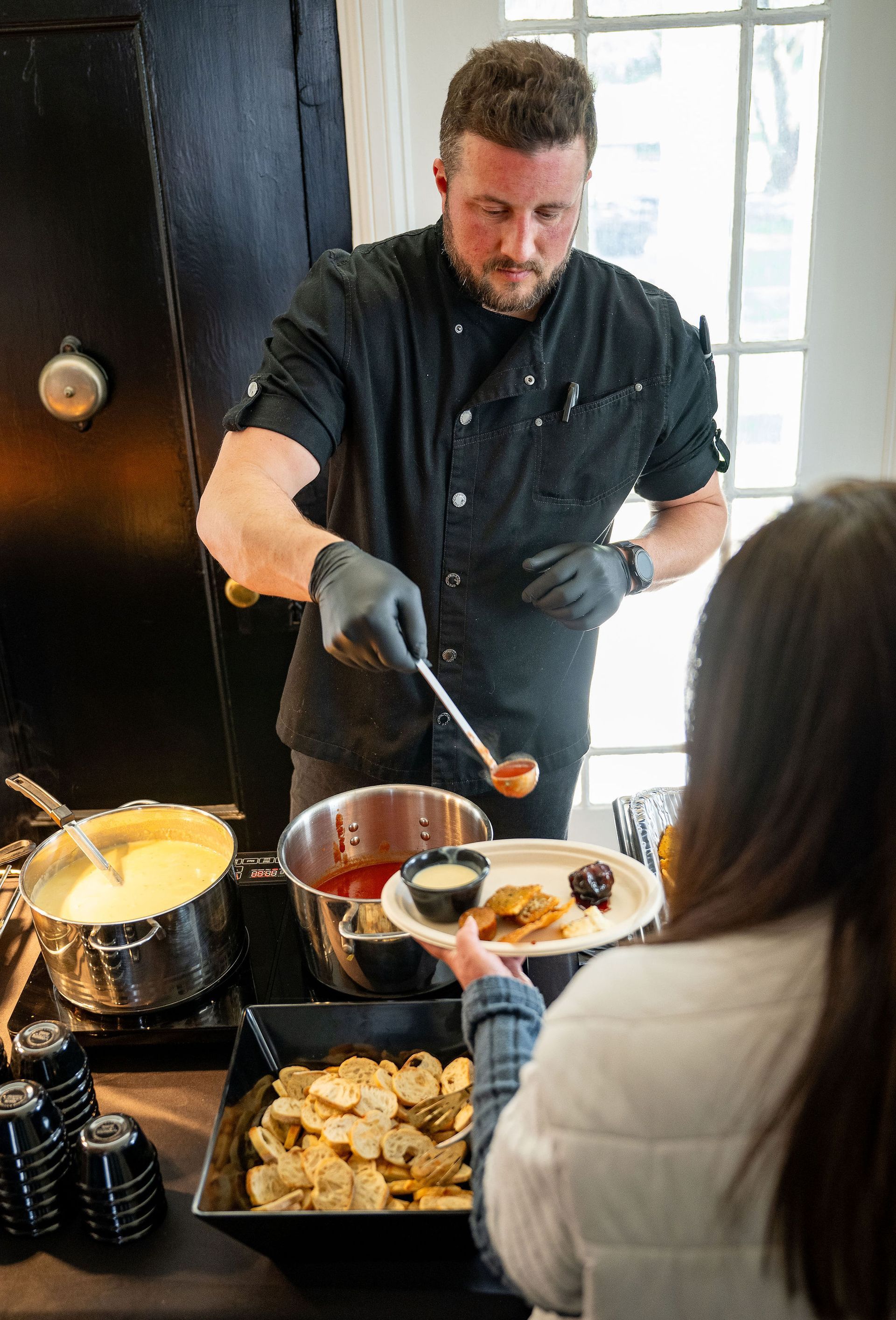 A man is serving food to a woman in a kitchen.