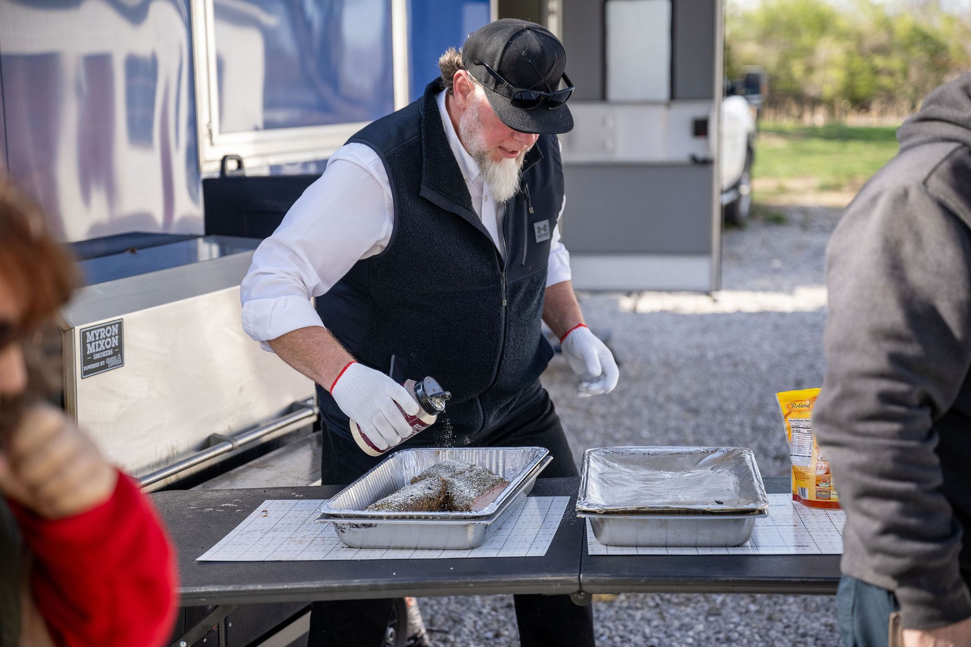 A man is standing at a table preparing food.