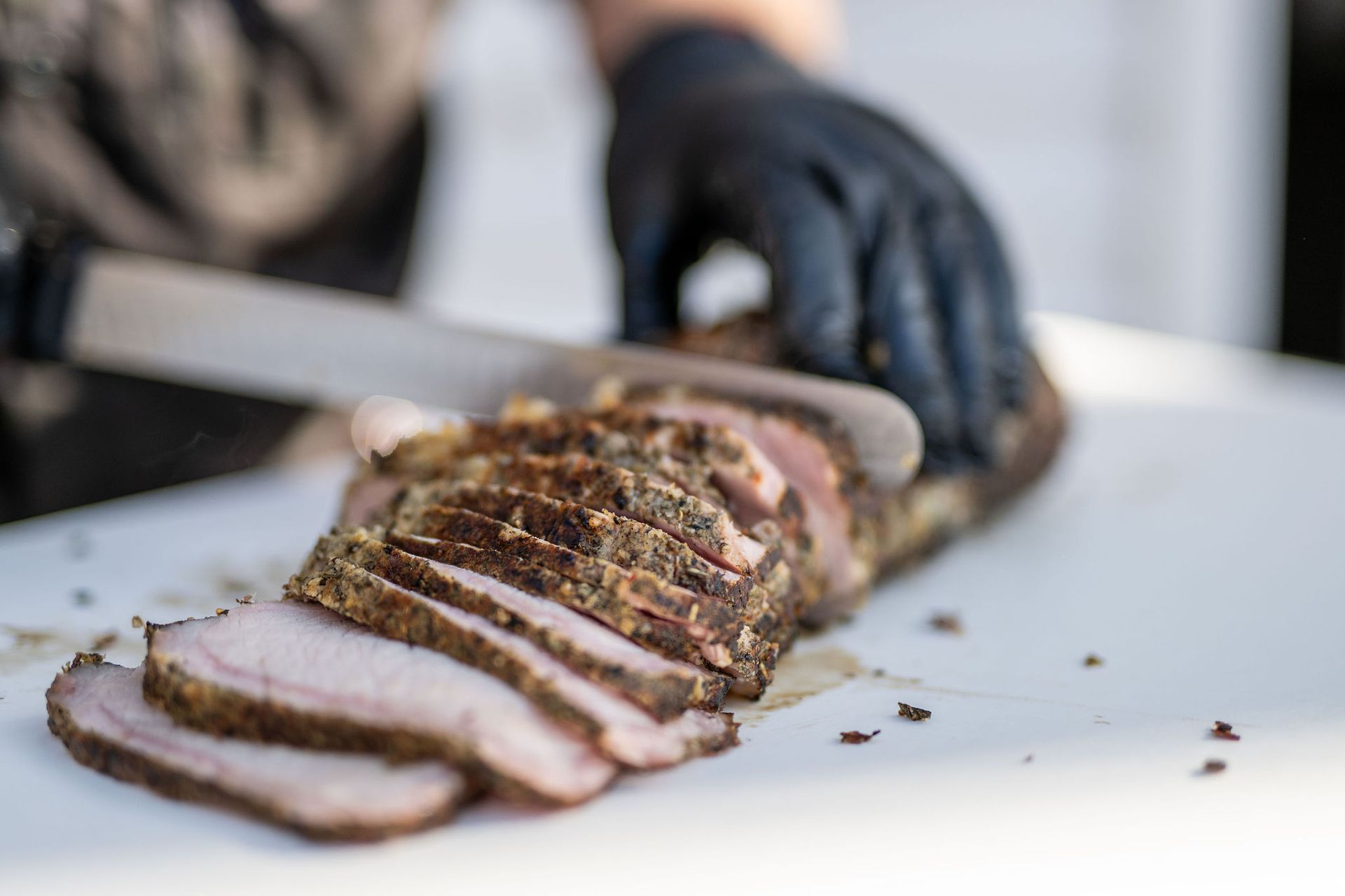 A person is cutting a piece of meat on a cutting board.