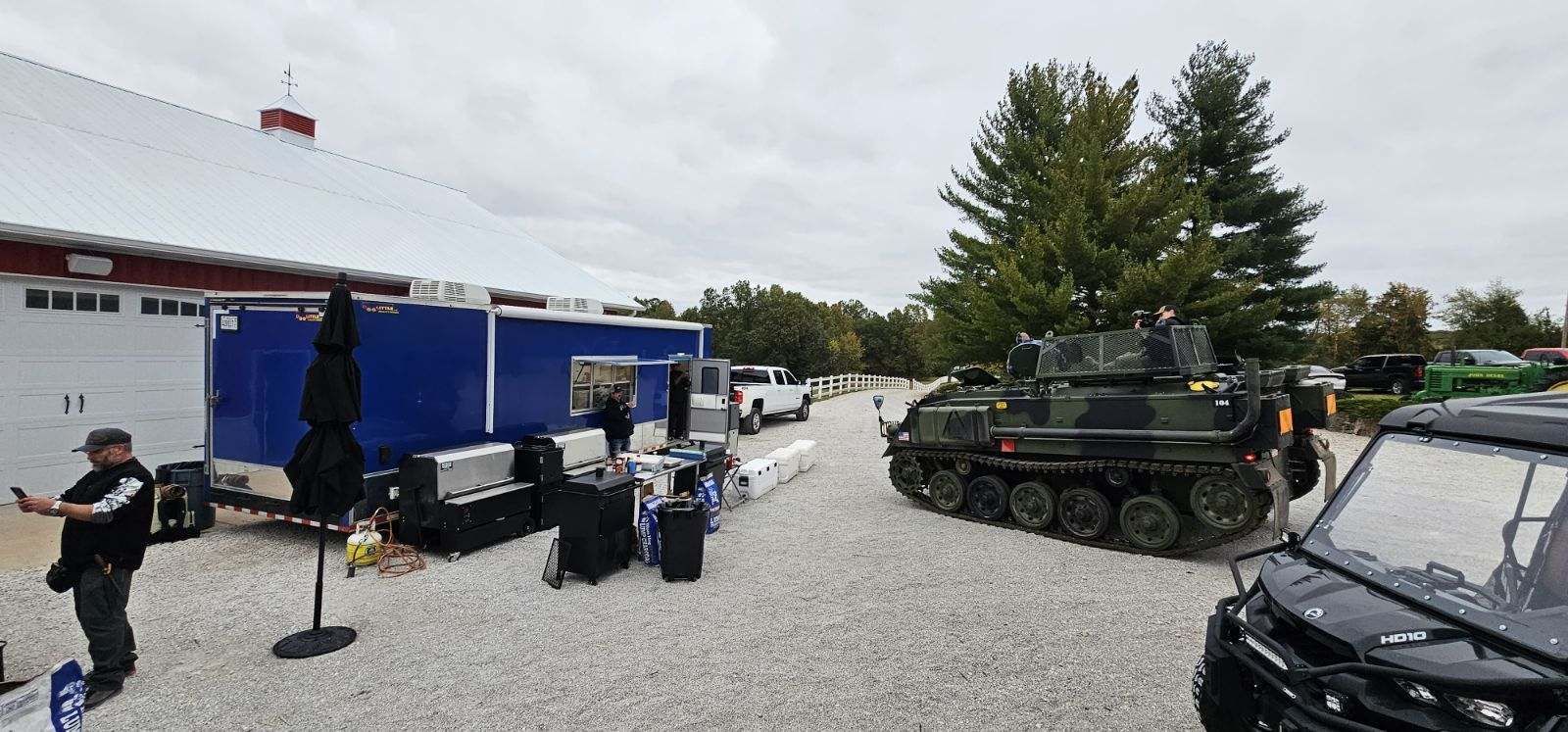 A man is taking a picture of a tank in a parking lot.