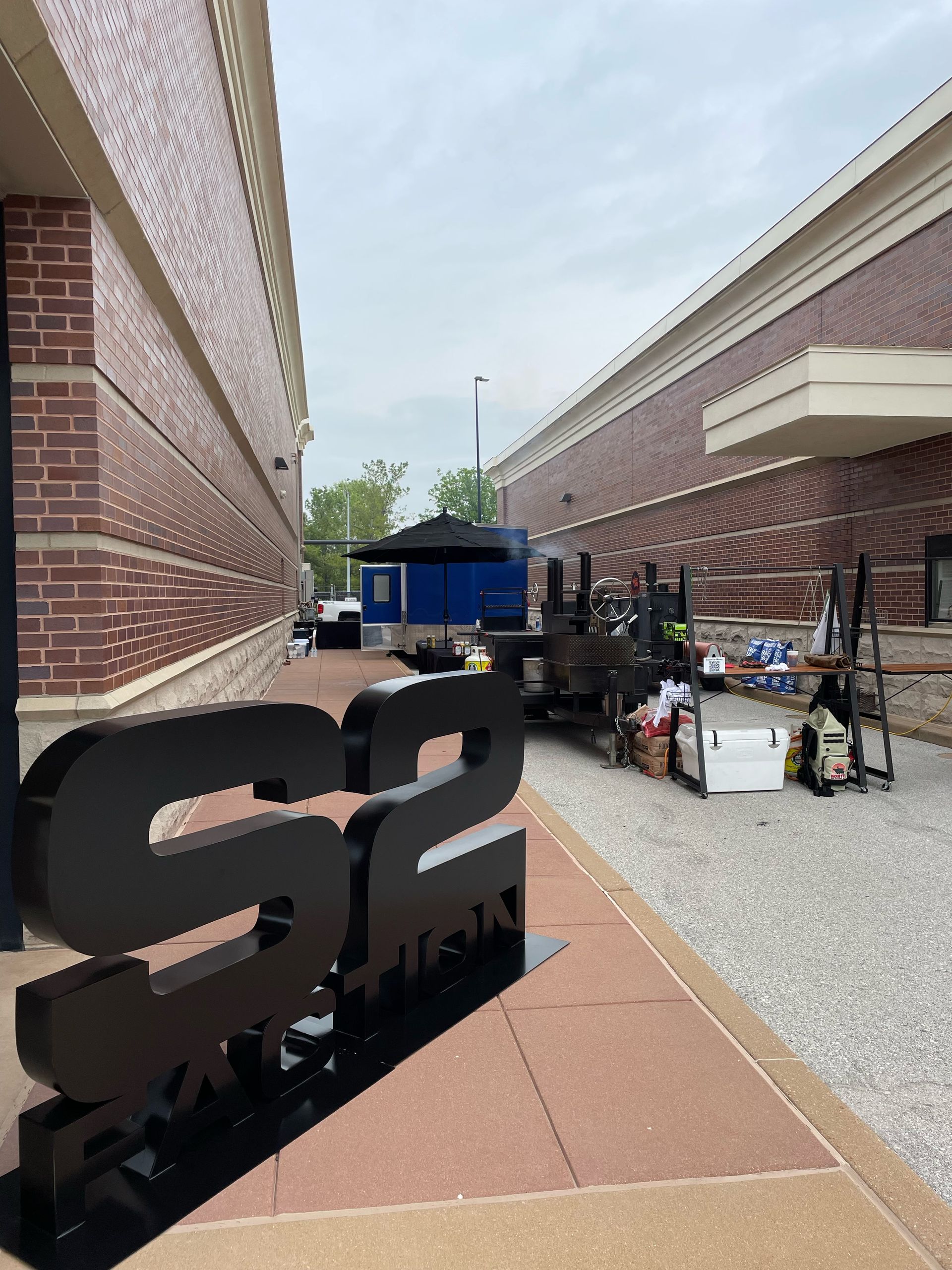 A large black s2 sign is in front of a brick building