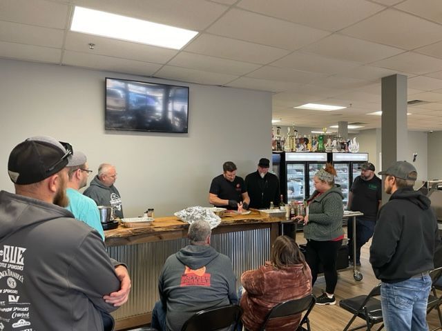 A group of people are standing around a table in a room.