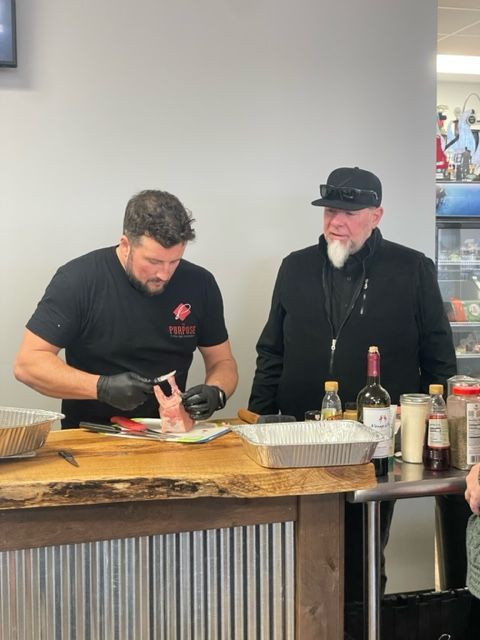 Two men are preparing food at a counter in a restaurant.