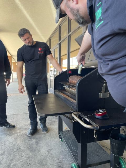 A man with a prosthetic leg is standing next to a grill