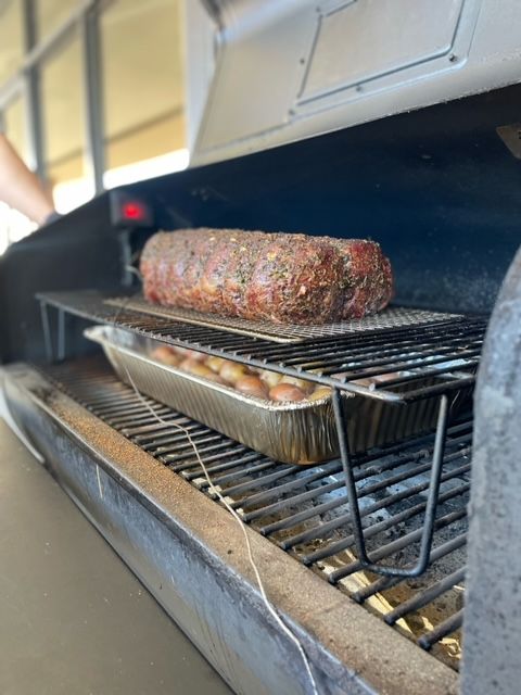 A large piece of meat is cooking on a grill.