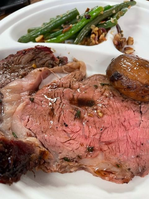 A white plate topped with meat and green beans