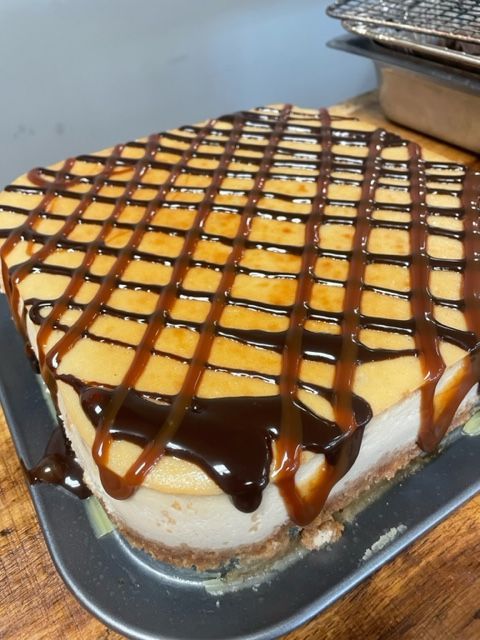 A cheesecake with caramel and chocolate sauce on top