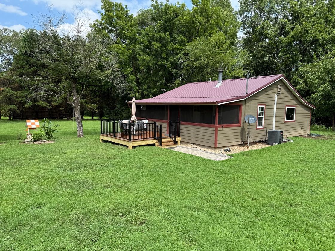 A small house with a well in front of it