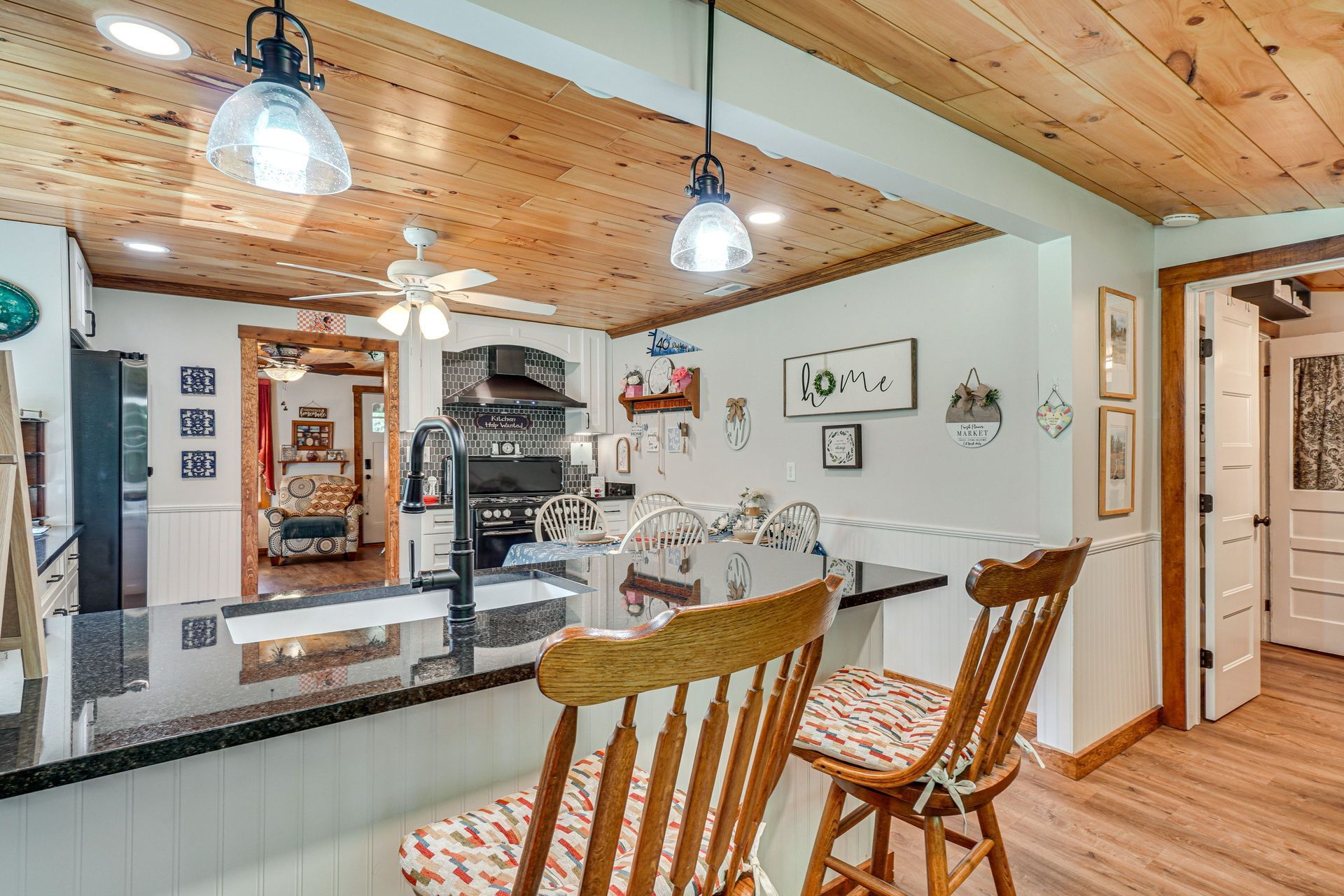 A kitchen with a table and chairs and a wooden ceiling.