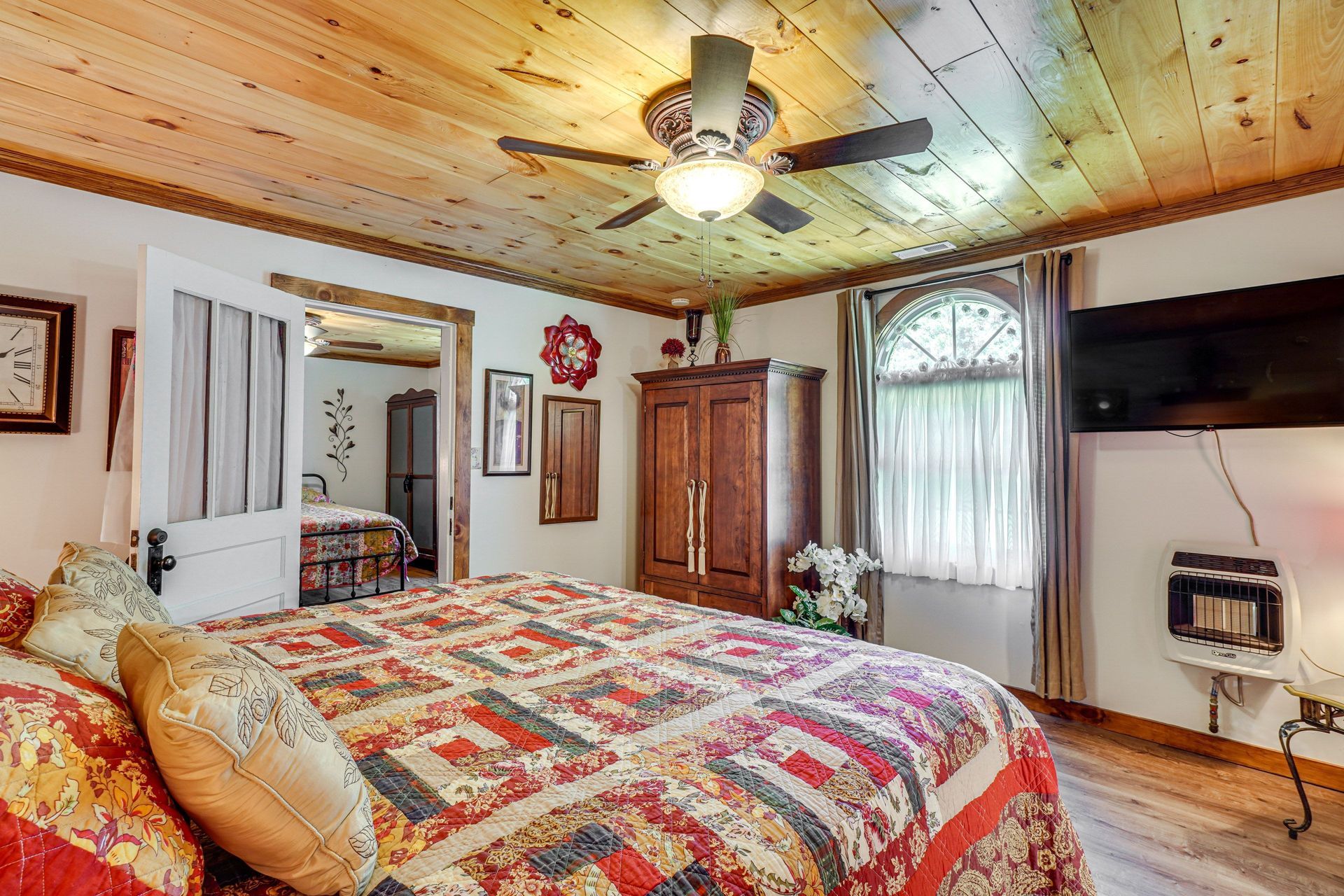 A bedroom with a king size bed and a ceiling fan.