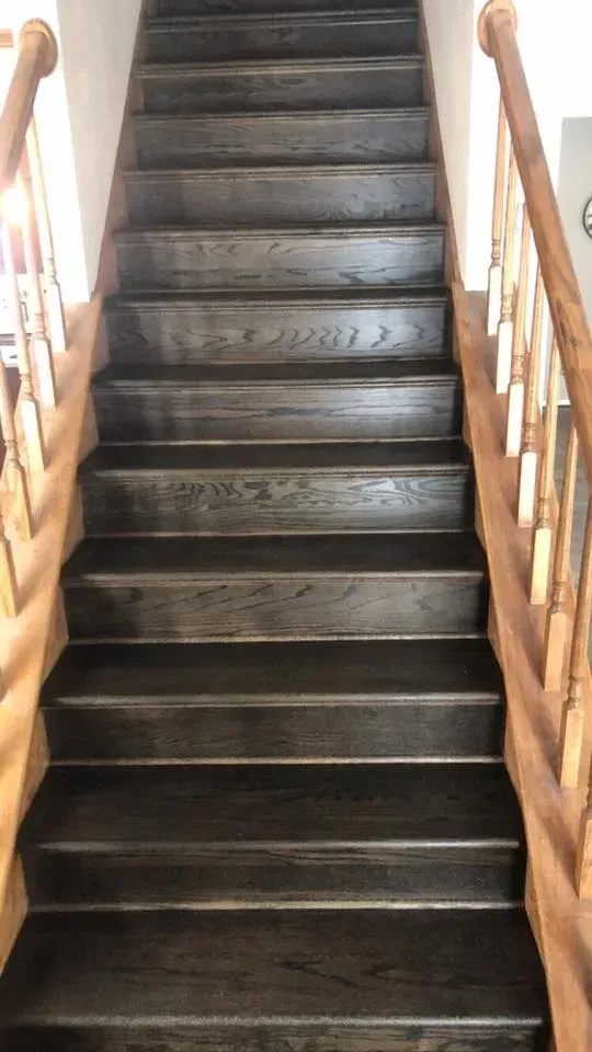 Dark wood staircase with wooden handrails.