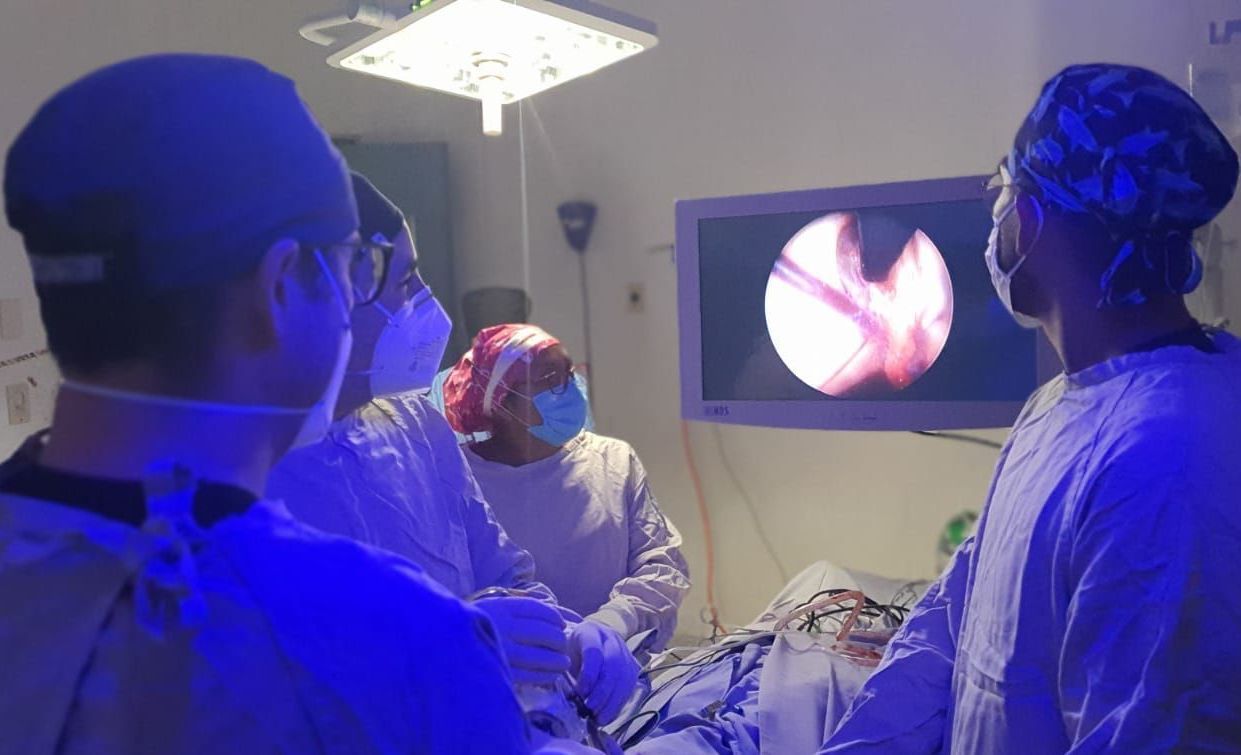 Un grupo de cirujanos está operando a un paciente en un quirófano.