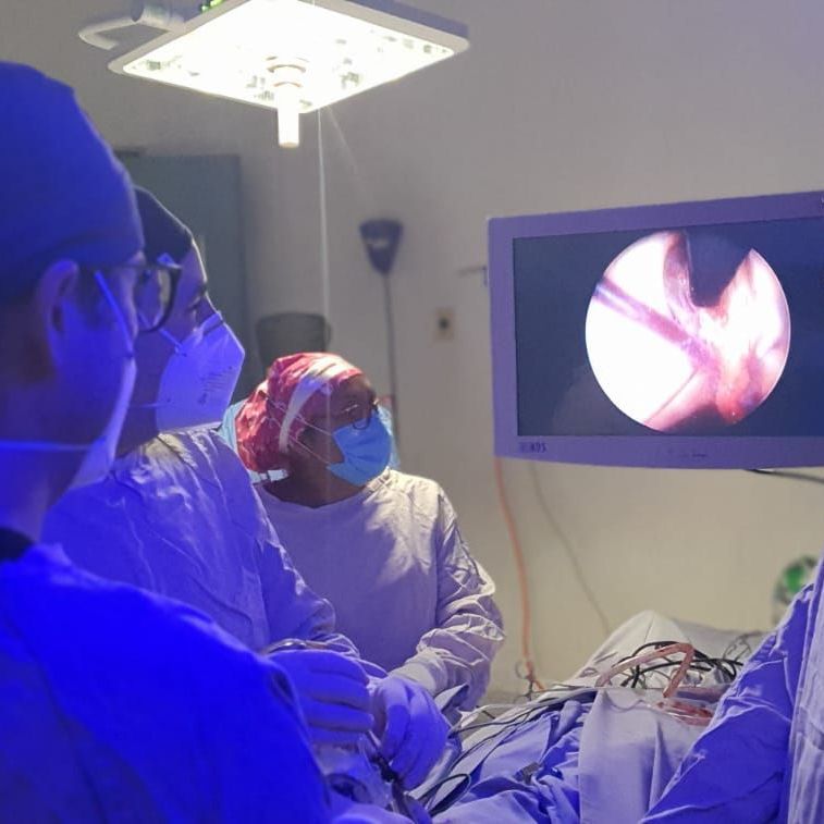 Un grupo de cirujanos está operando a un paciente en un quirófano.