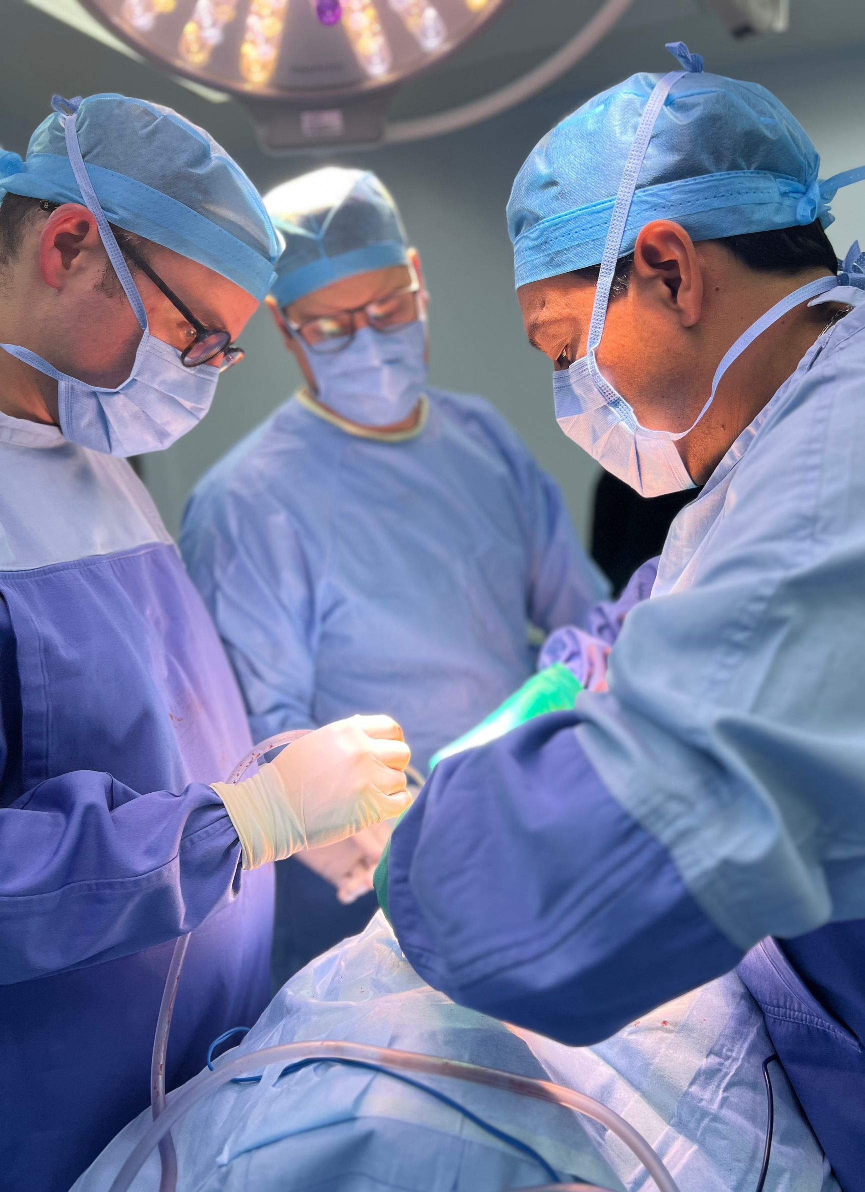 Un grupo de cirujanos está operando a un paciente en un quirófano.