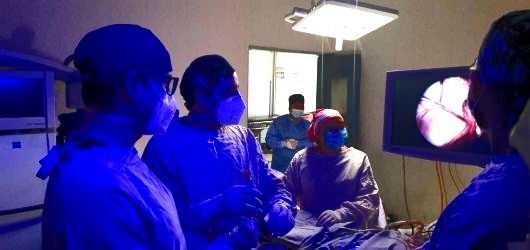 Un grupo de cirujanos está operando a un paciente en un quirófano.