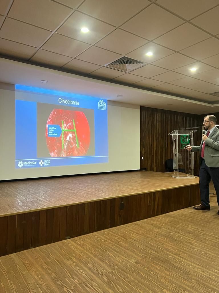 Dr Martínez Manriqueestá dando una presentación frente a una pantalla grande en una sala.