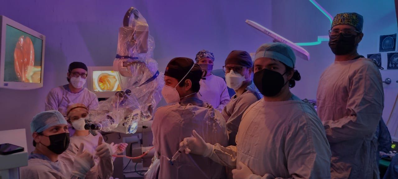 Un grupo de cirujanos está operando a un paciente en un quirófano.