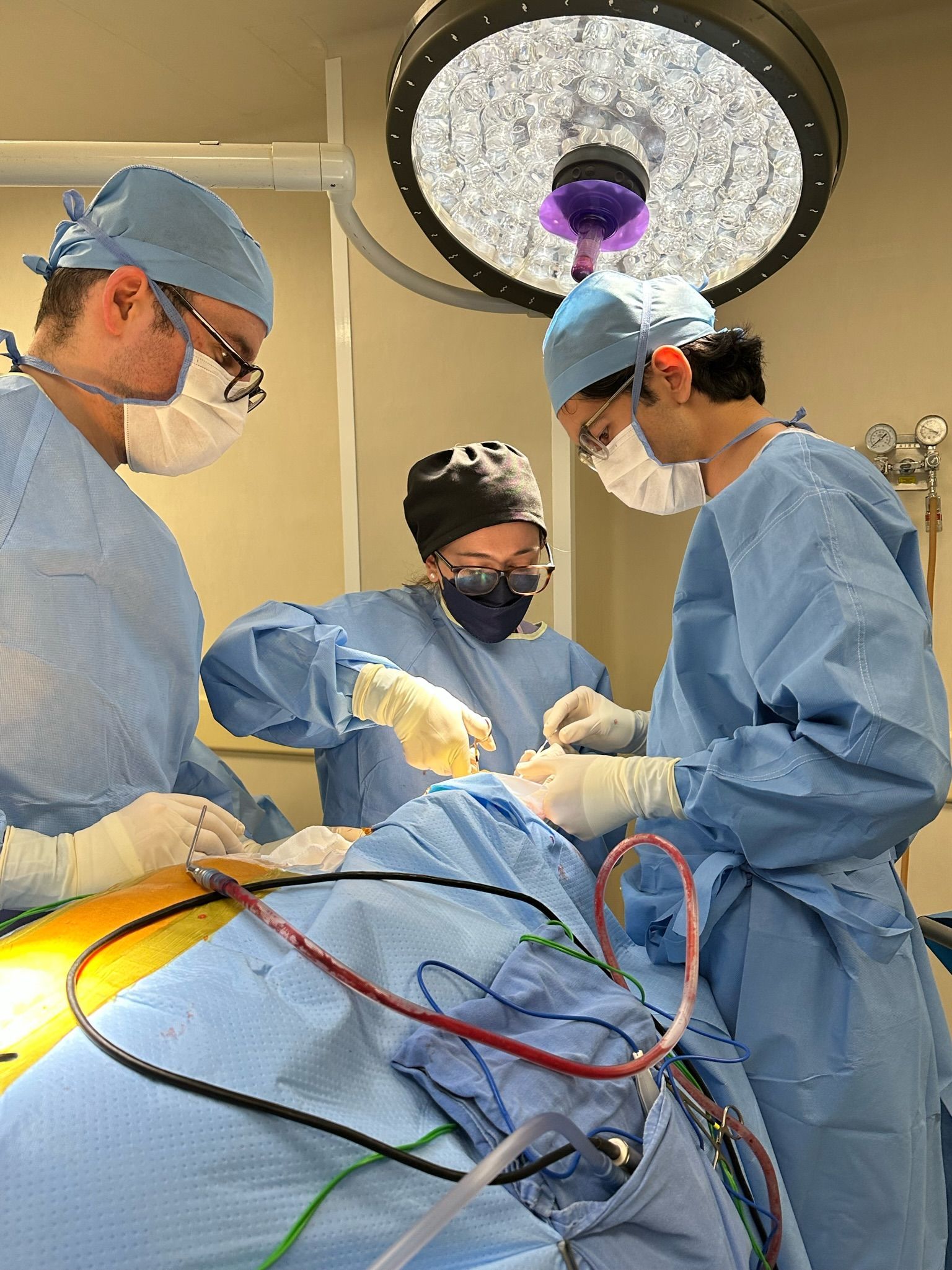 Un grupo de cirujanos está operando a un paciente en un quirófano.