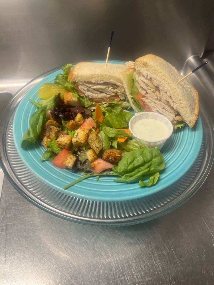 A blue plate topped with a sandwich and a salad.