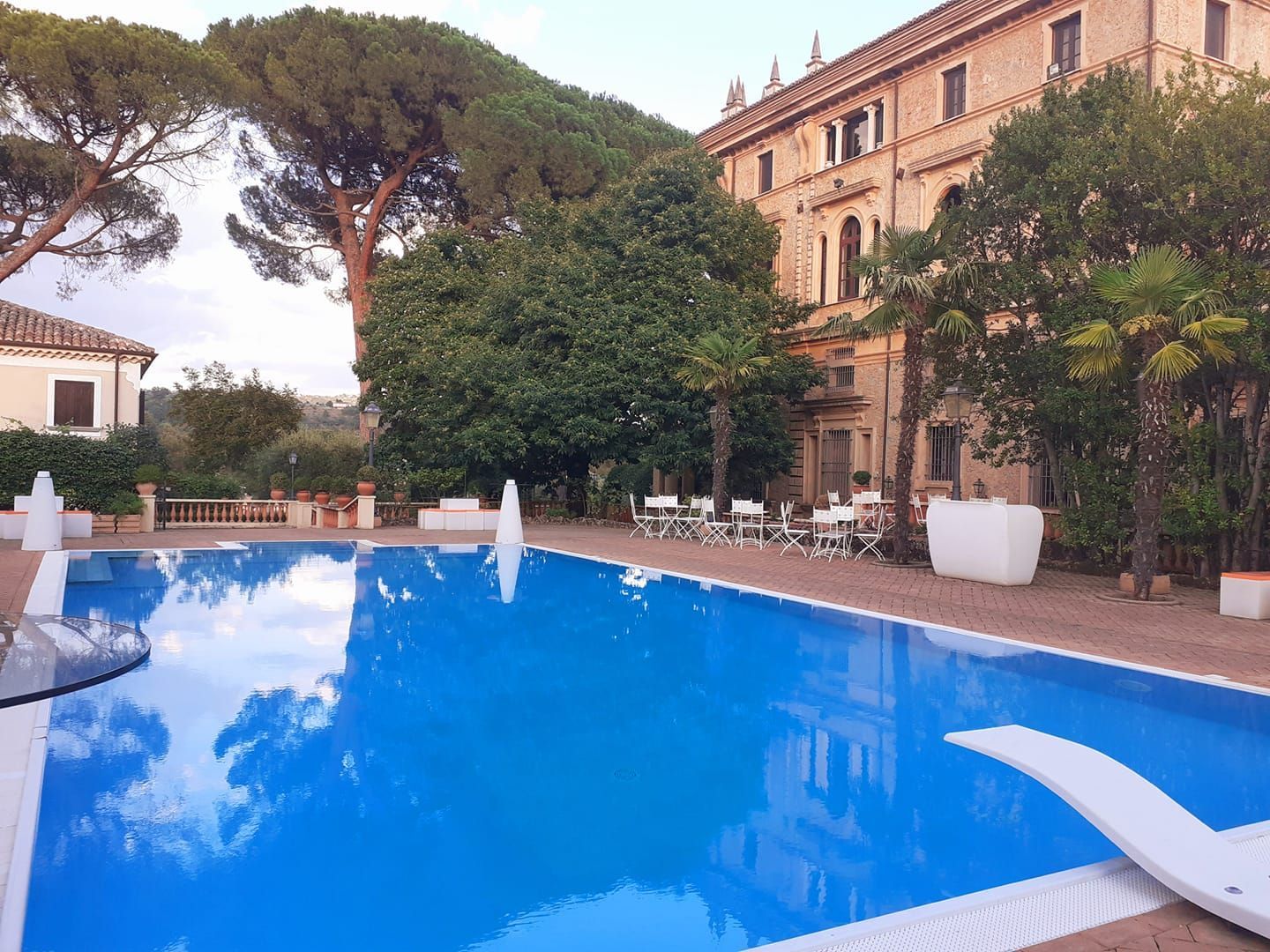 Una grande piscina con un grande edificio sullo sfondo