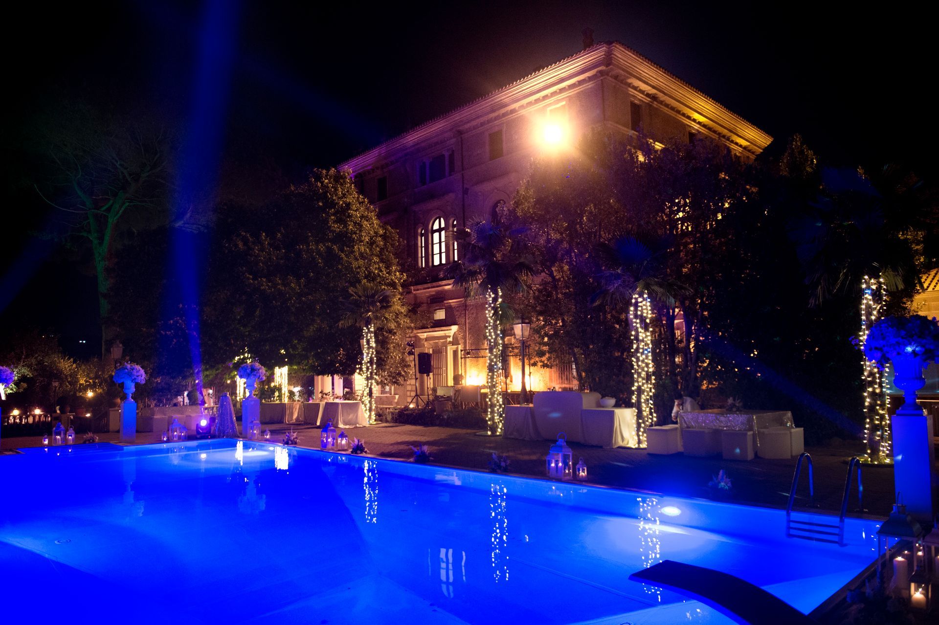 Una grande piscina è illuminata di notte con luci blu