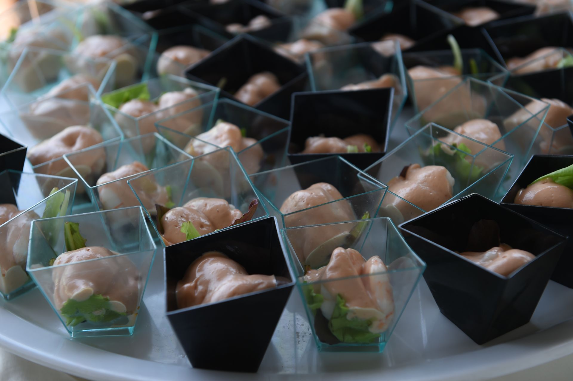 Un vassoio di tazzine piene di cibo su un tavolo.