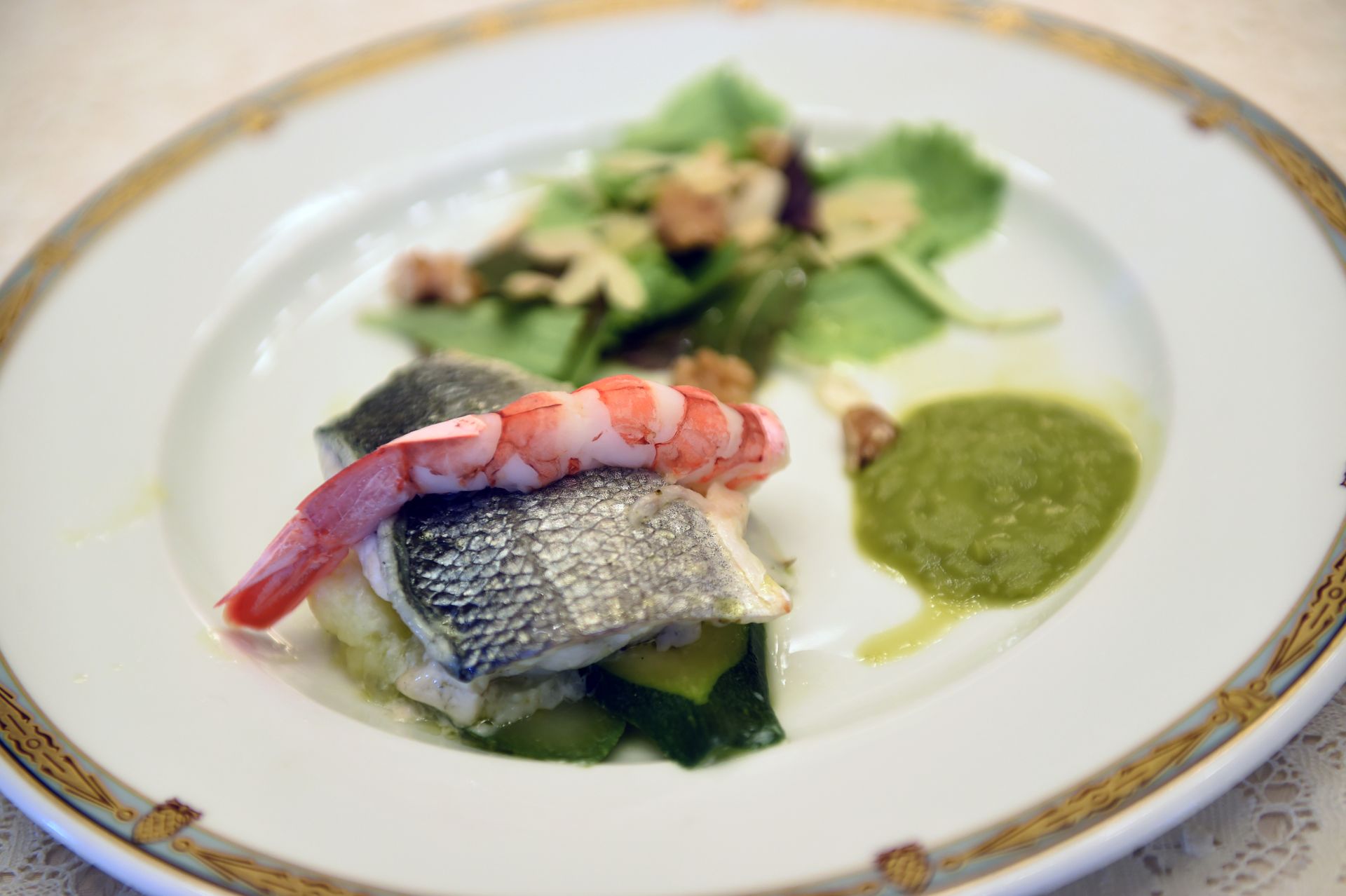 Un piatto di cibo con gamberetti e verdure su un tavolo.