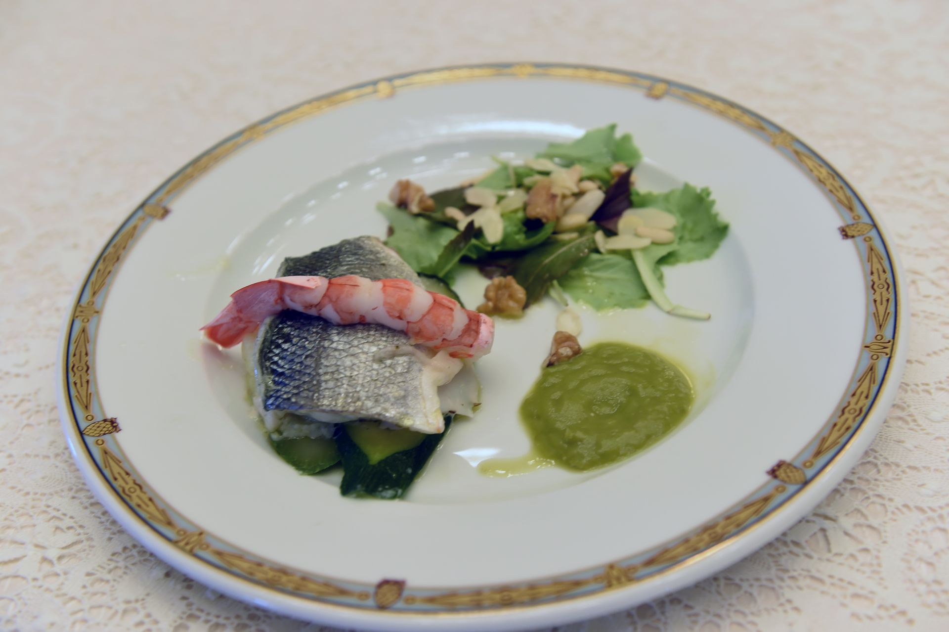 Un piatto di cibo con gamberetti e verdure su un tavolo.