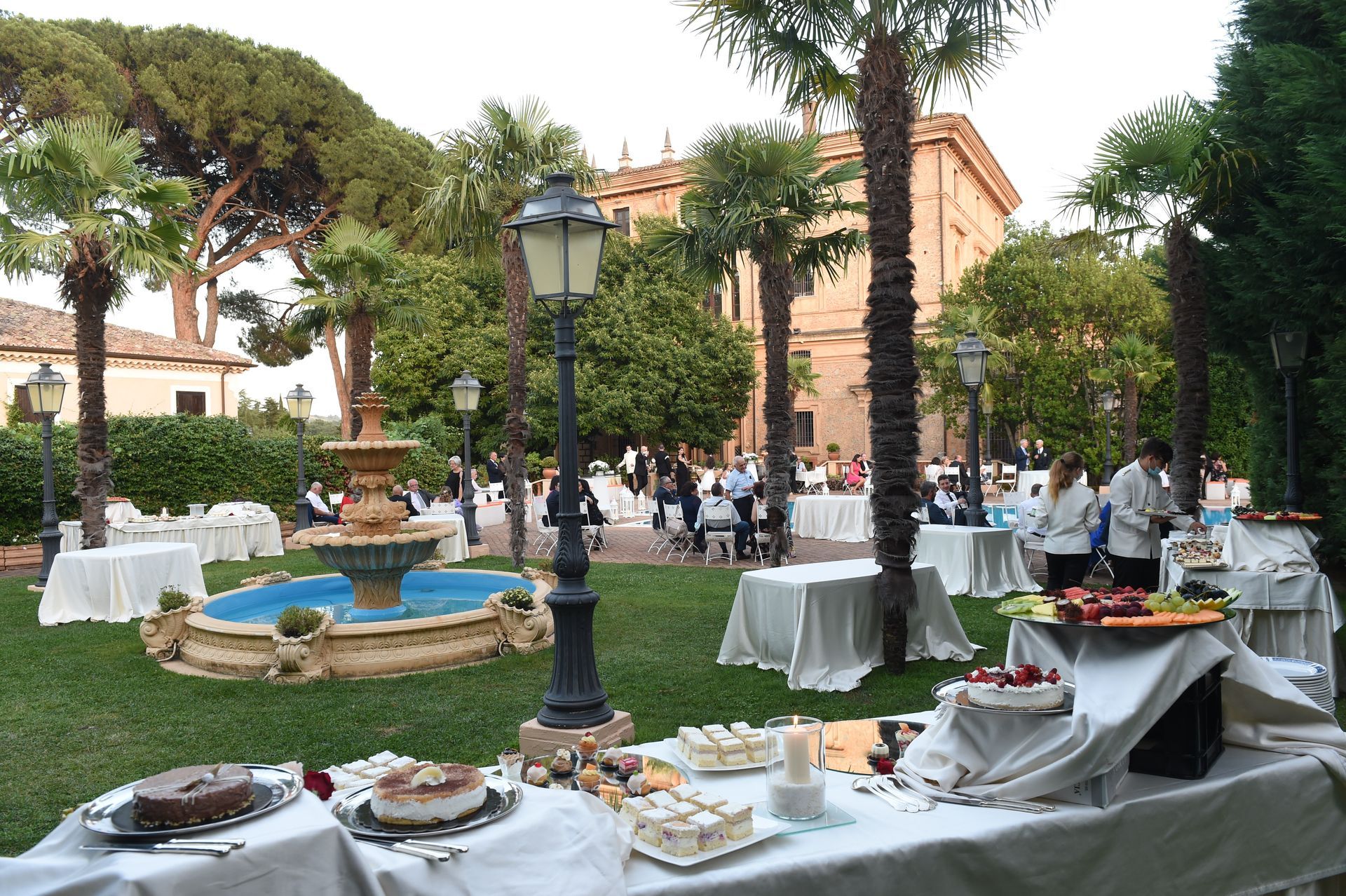 Un tavolo da buffet in un parco con una fontana sullo sfondo