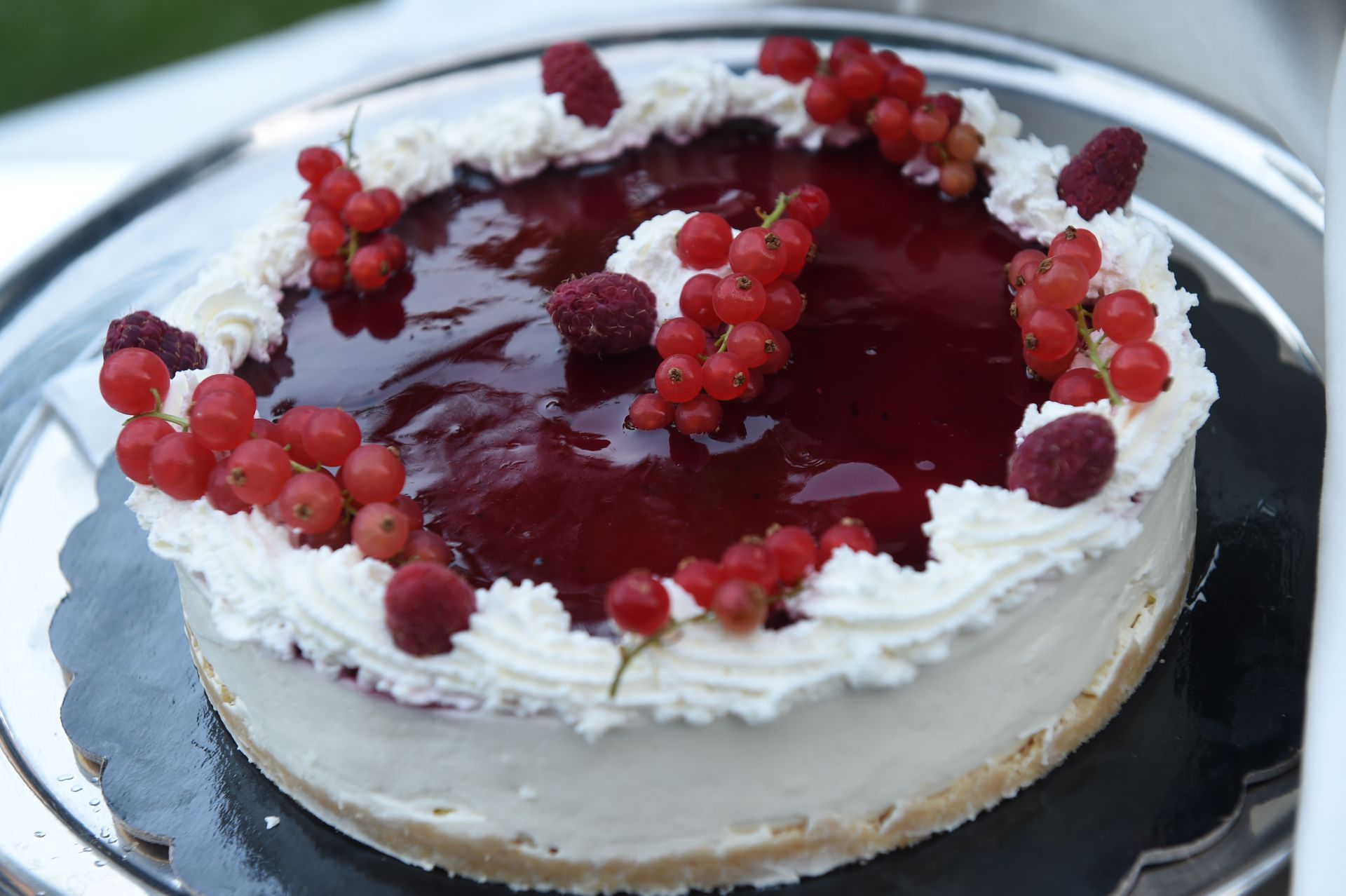 Una cheesecake con sopra lamponi e ribes rosso