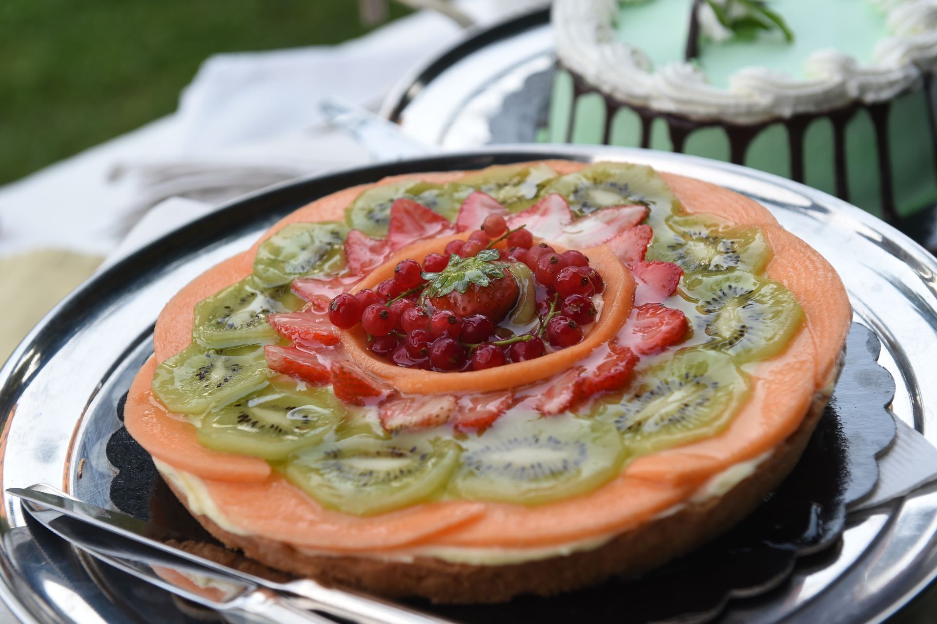 Una torta con sopra fette di kiwi e fragole