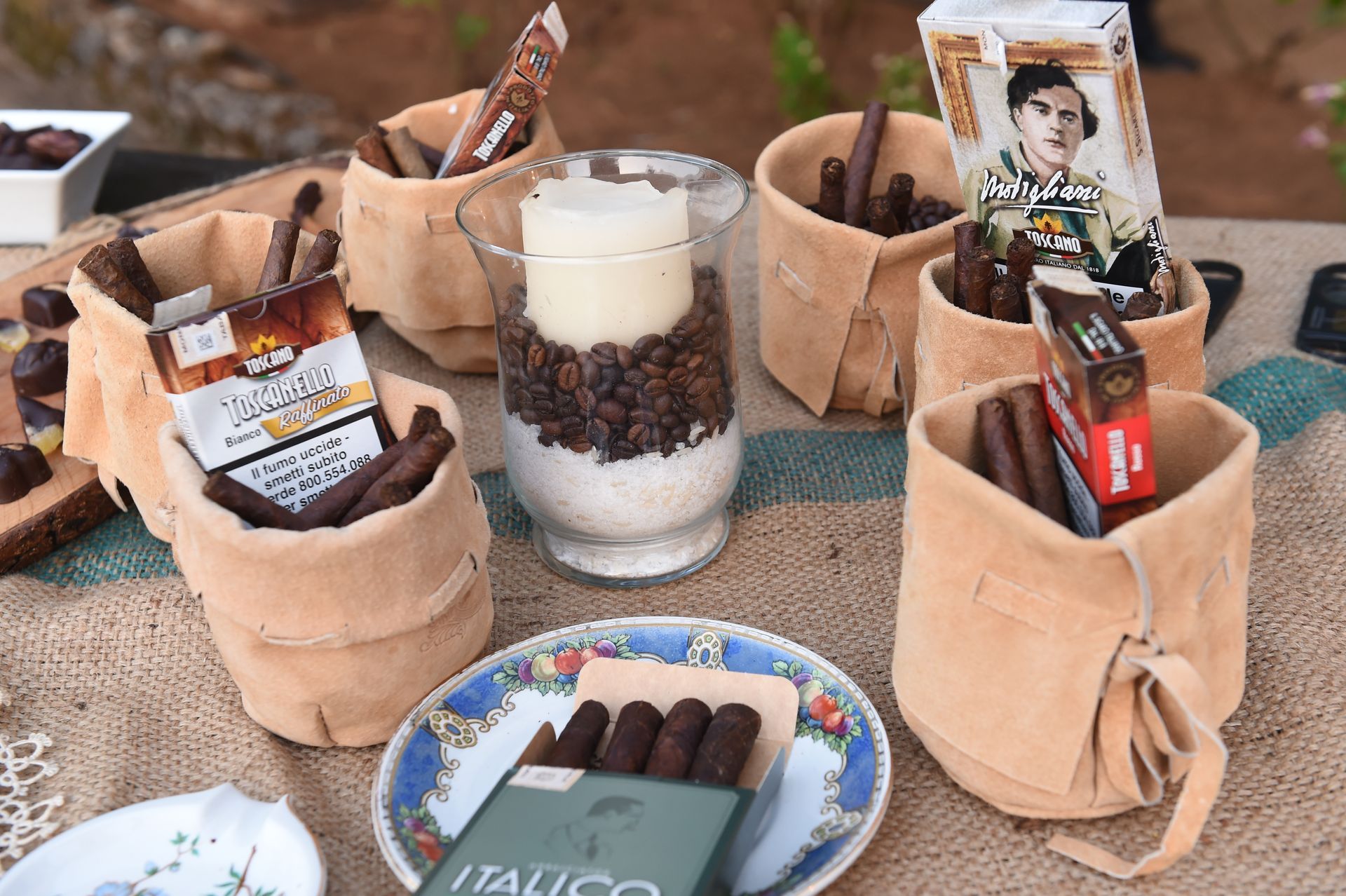 Un tavolo sormontato da sacchetti di sigari e una candela.