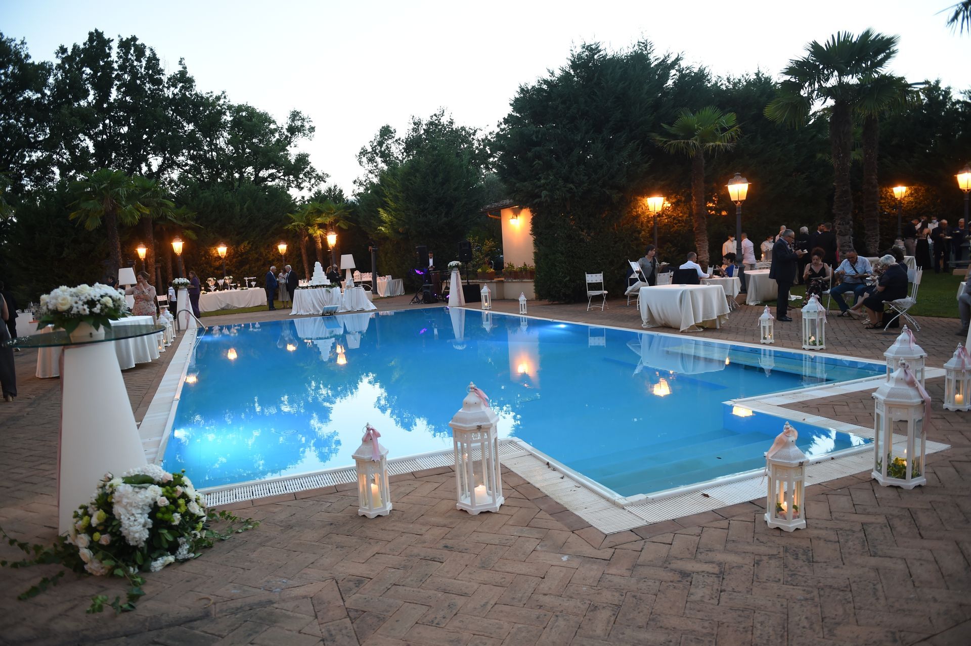 Una grande piscina è decorata con lanterne e fiori