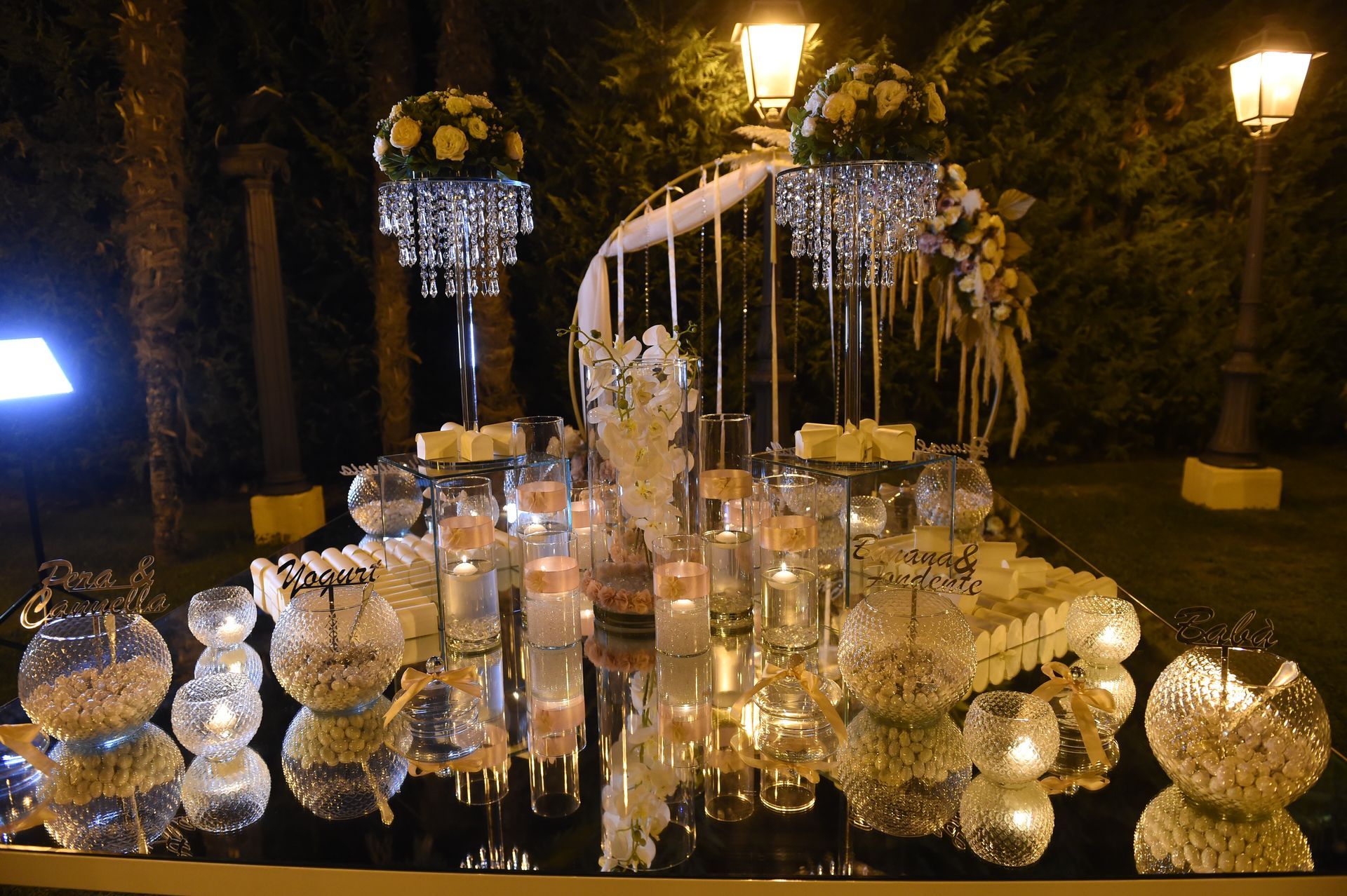 Un tavolo con candele e fiori sopra di notte