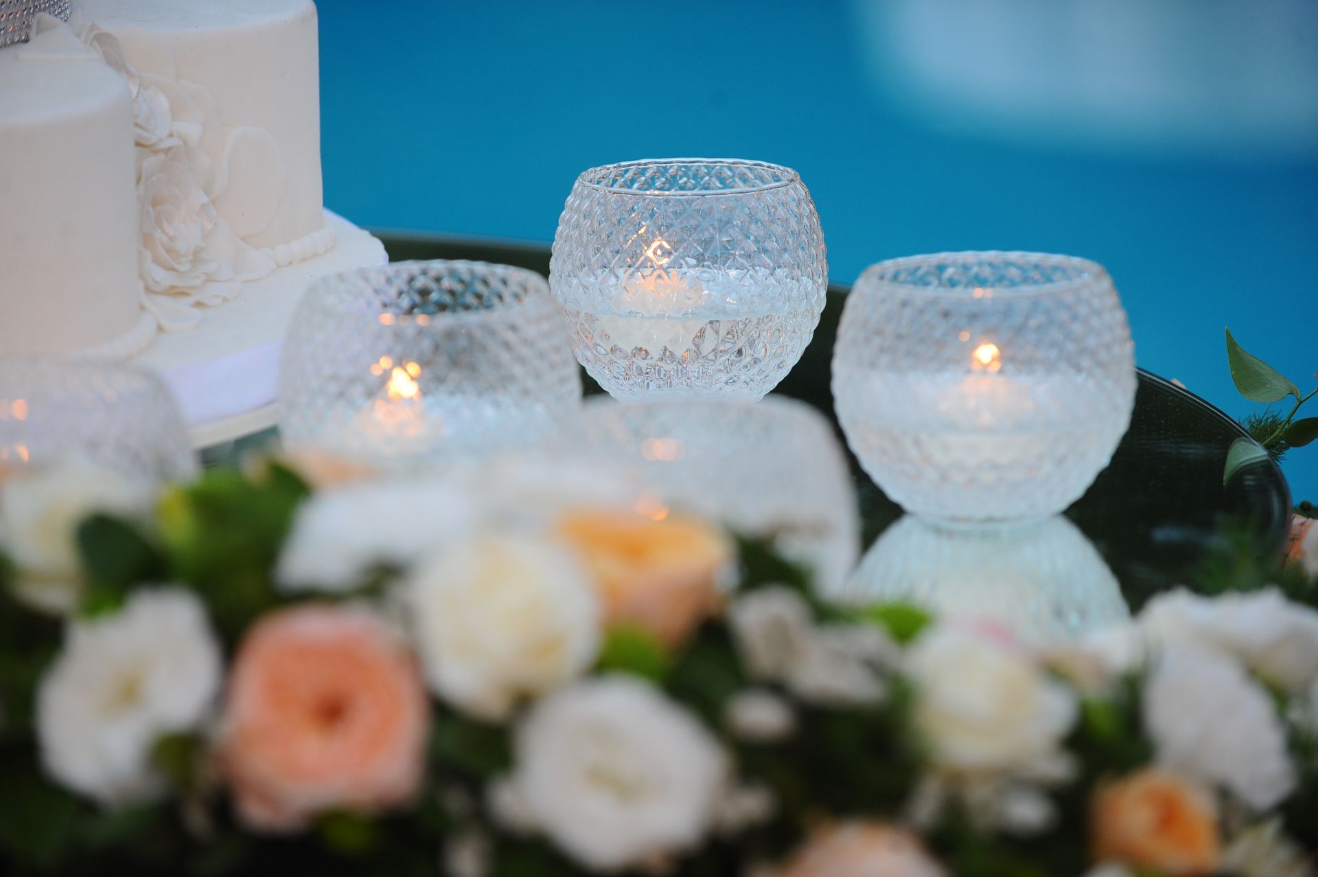 Un tavolo con candele e fiori davanti alla piscina.