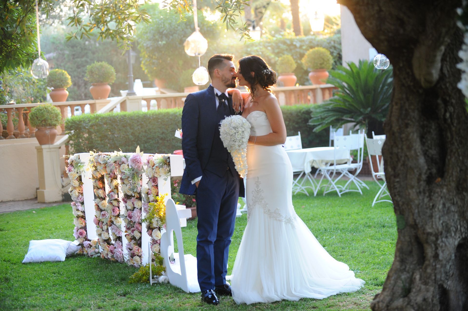 Gli sposi si baciano davanti ad un cartello che dice amore