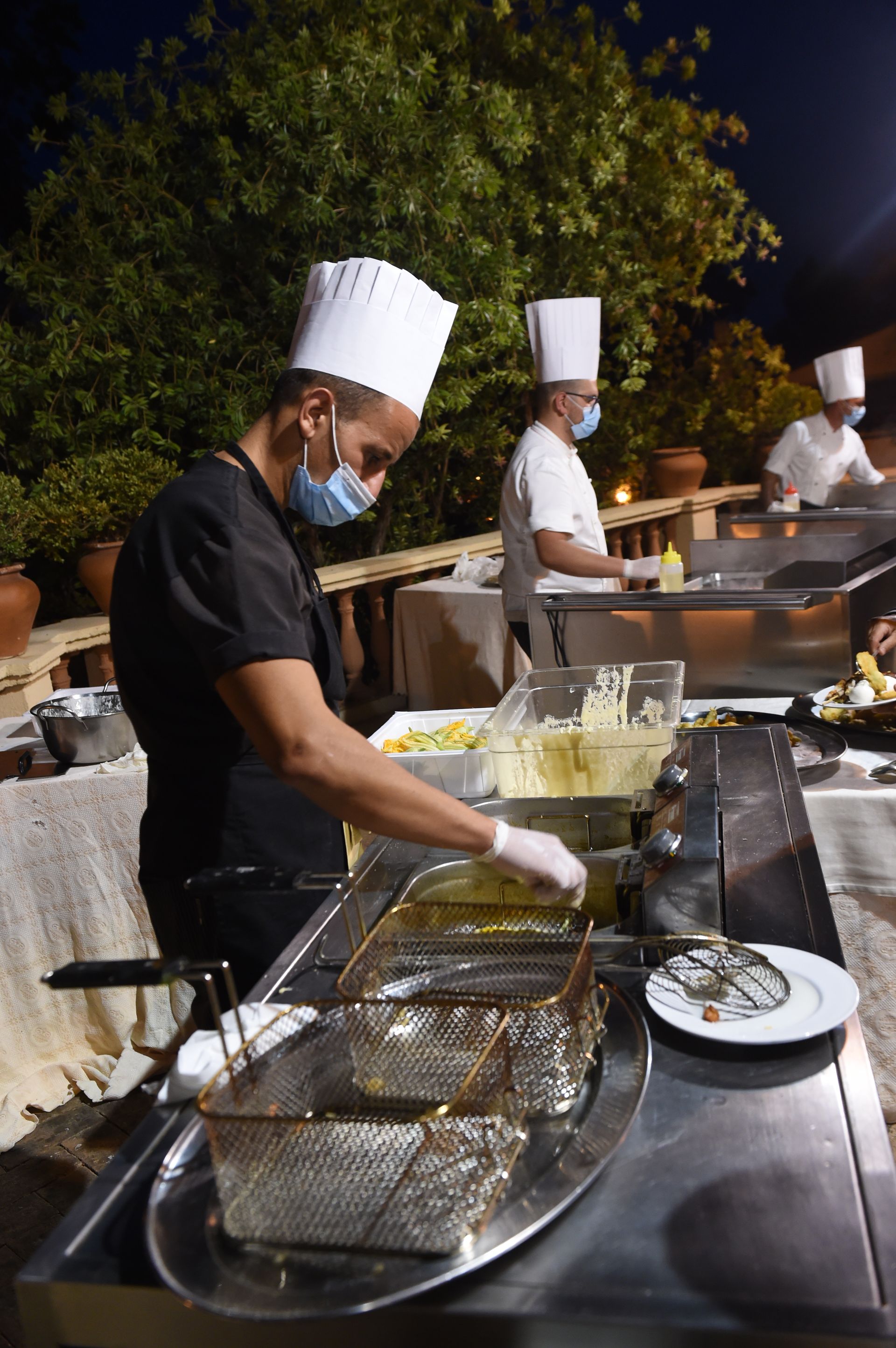 Un uomo con un cappello da chef sta preparando il cibo in una cucina.