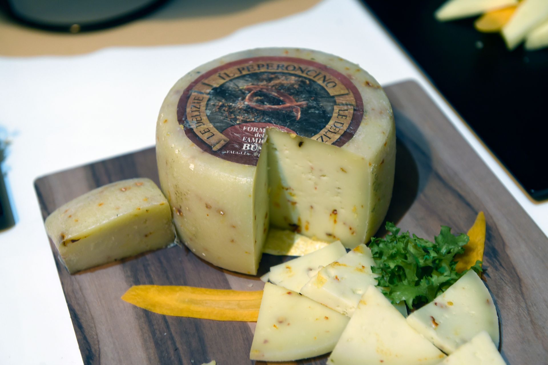 Una forma di formaggio è seduta su un tagliere di legno