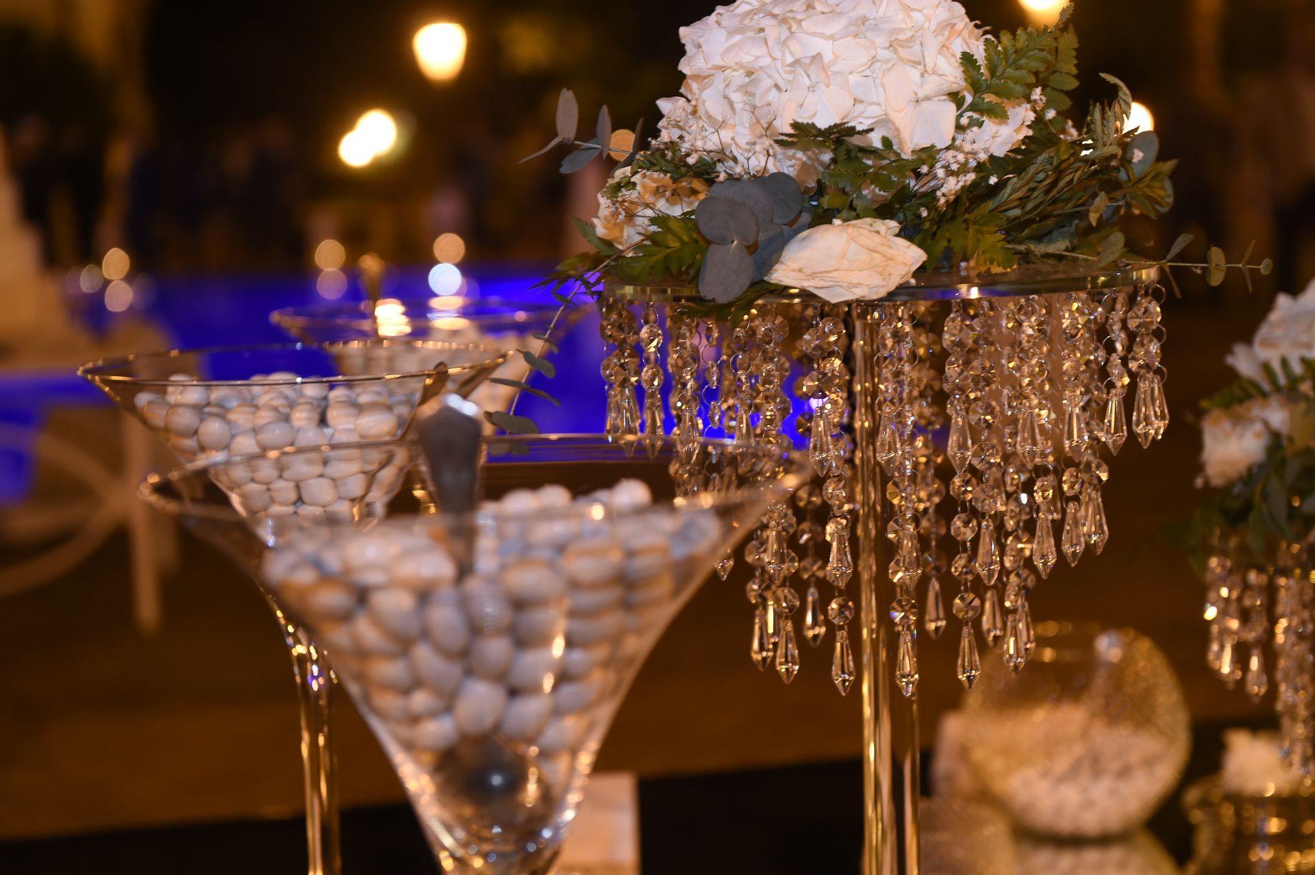 Un tavolo con bicchieri da martini pieni di coriandoli e fiori.