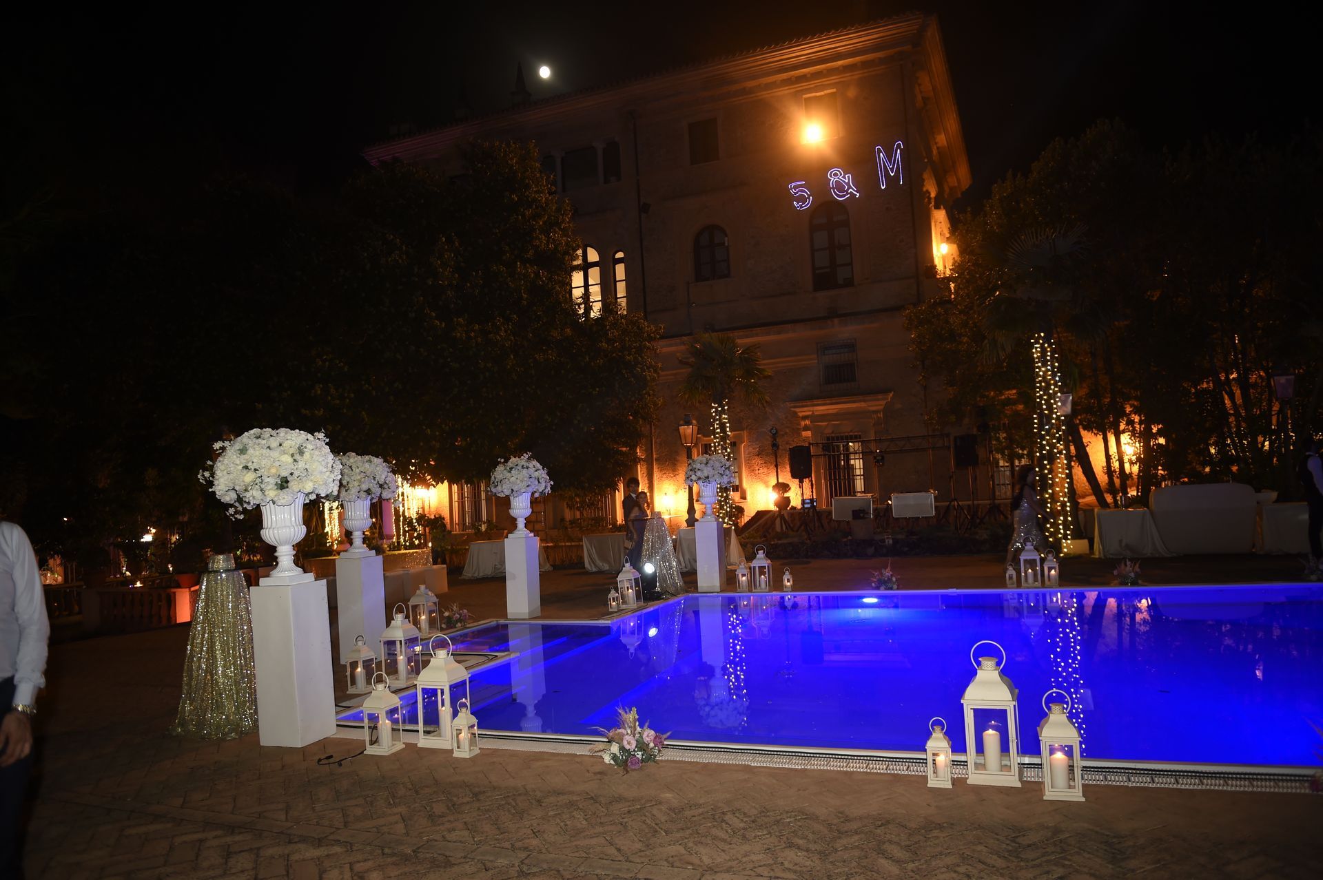 Una piscina decorata con lanterne e fiori di notte