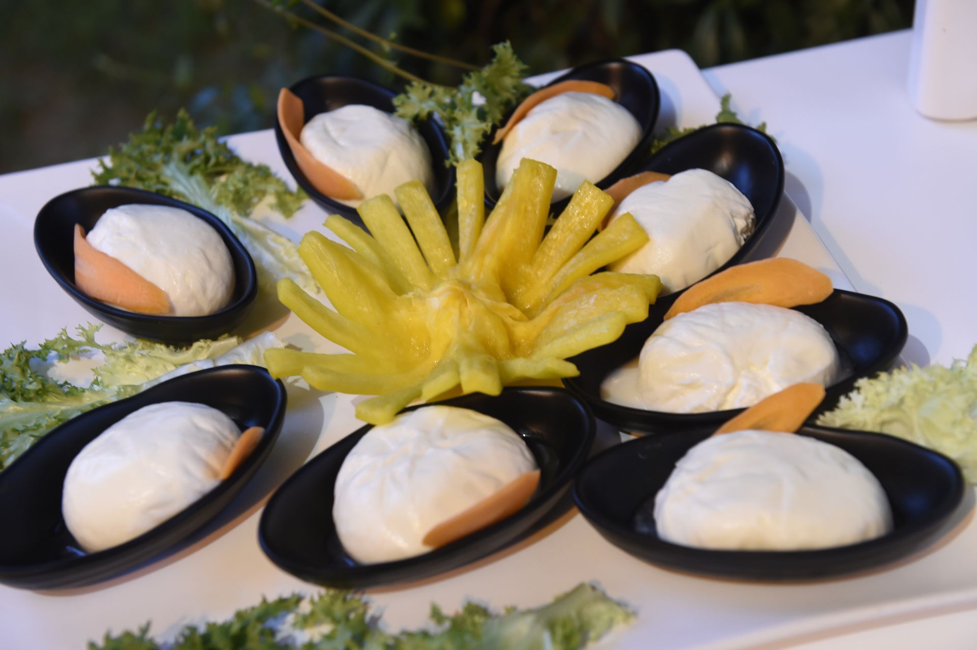 Un piatto di cibo con un fiore giallo al centro