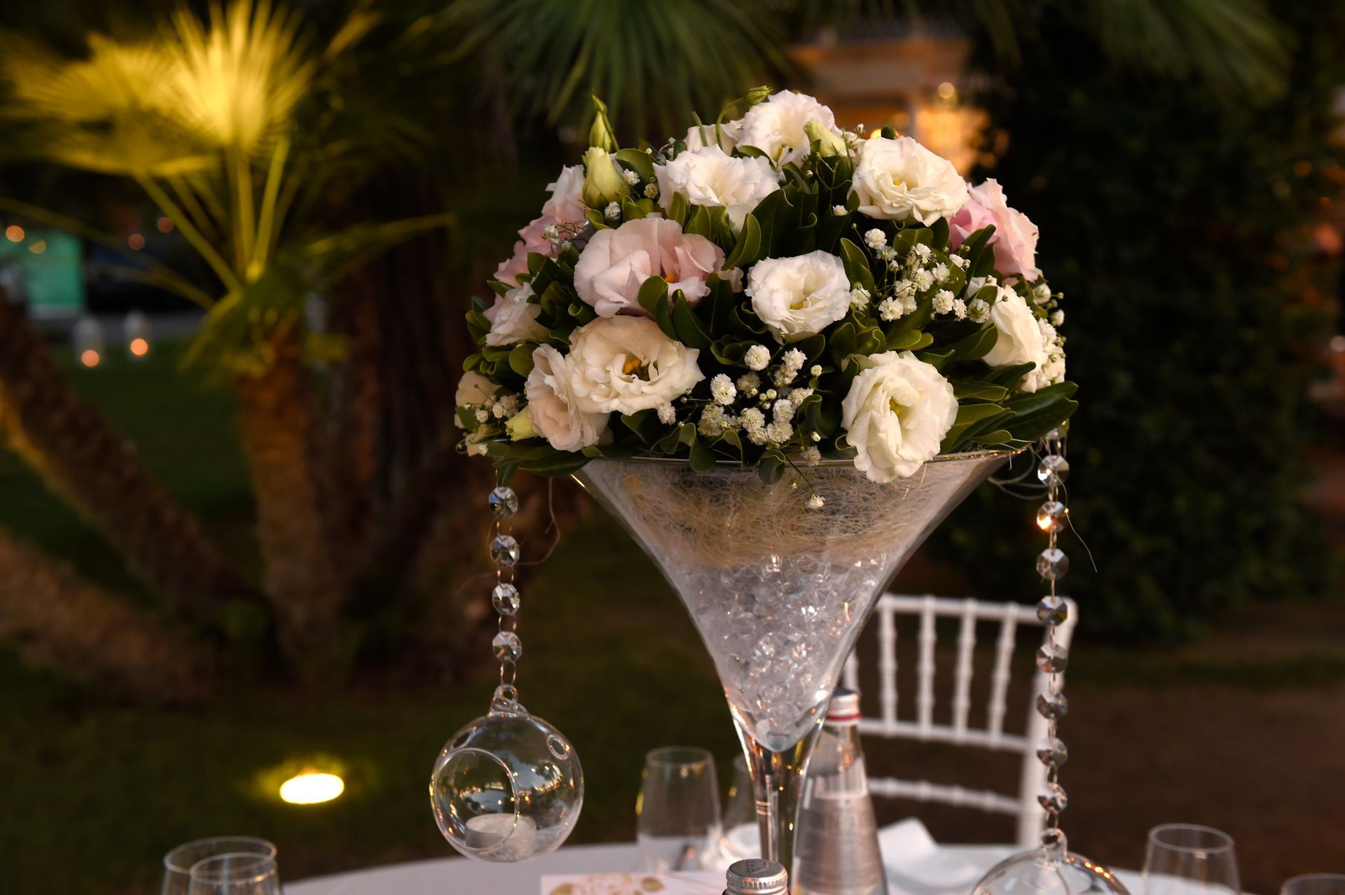 Su un tavolo c'è un bicchiere da martini pieno di fiori.