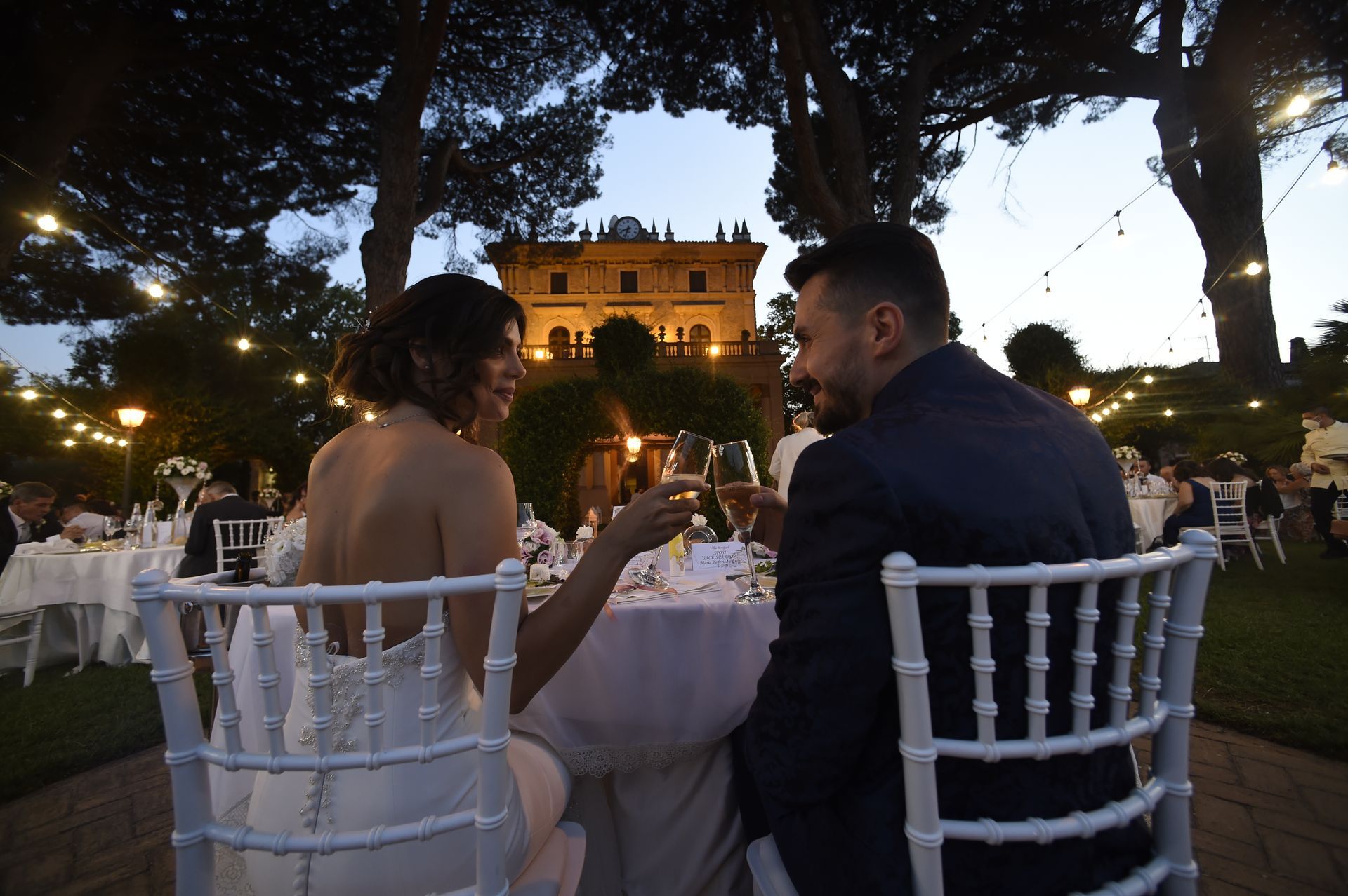 Gli sposi sono seduti a un tavolo con un grande edificio sullo sfondo