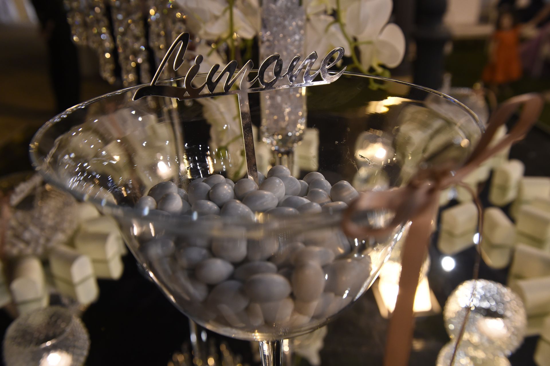 Un bicchiere da martini pieno di pietre grigie e un cartello che dice amore