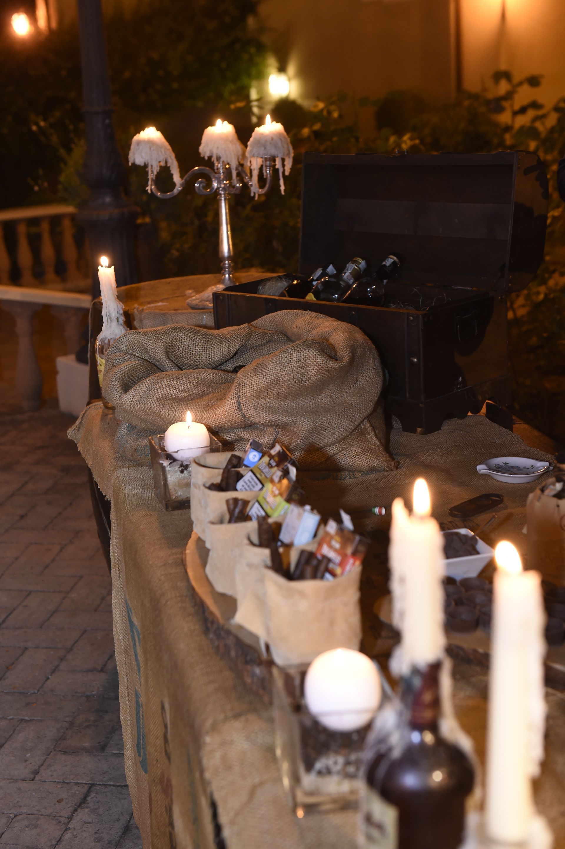 Un tavolo con sopra candele e bottiglie.