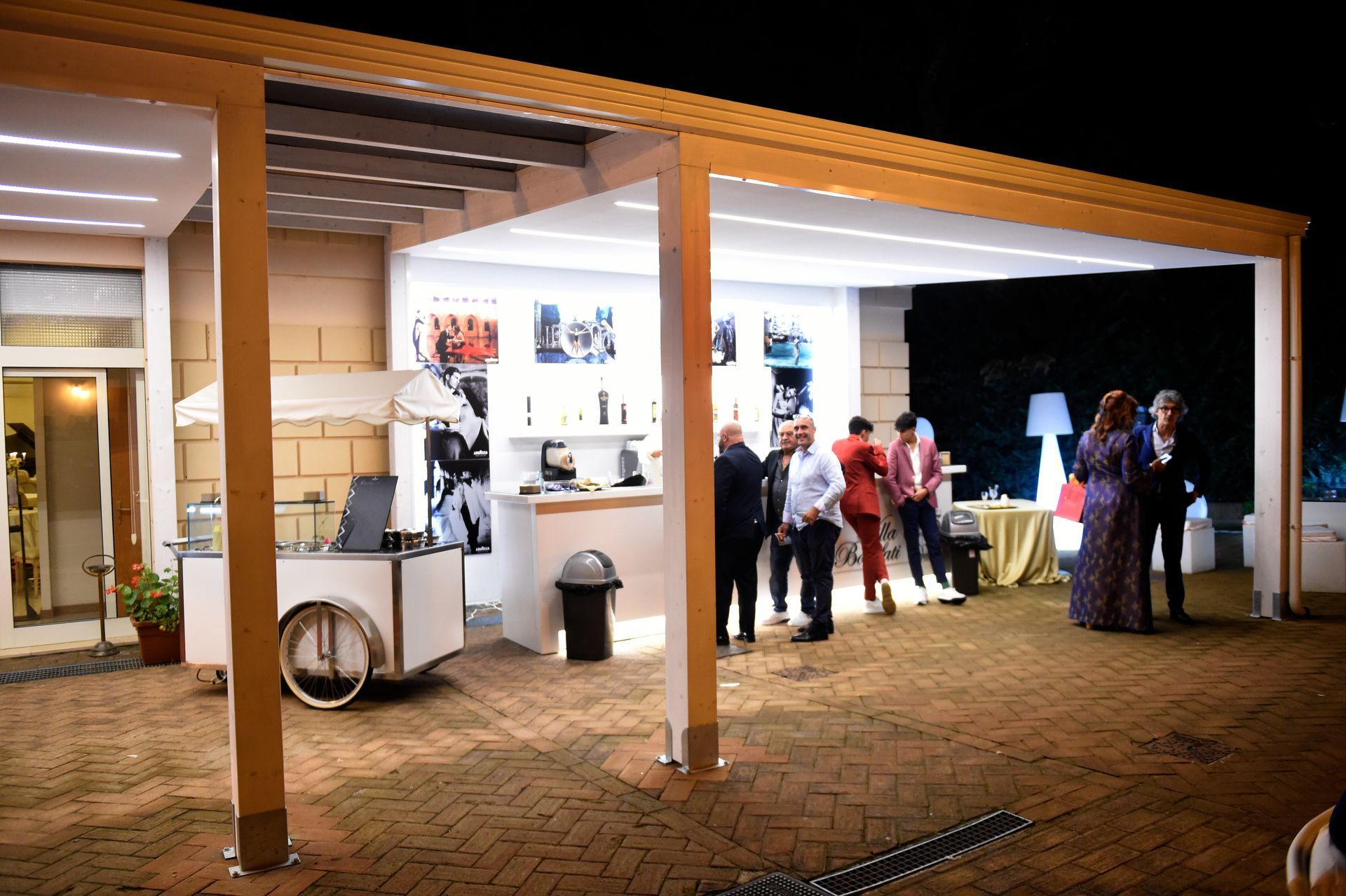 Un gruppo di persone si trova all'esterno di un edificio di notte.