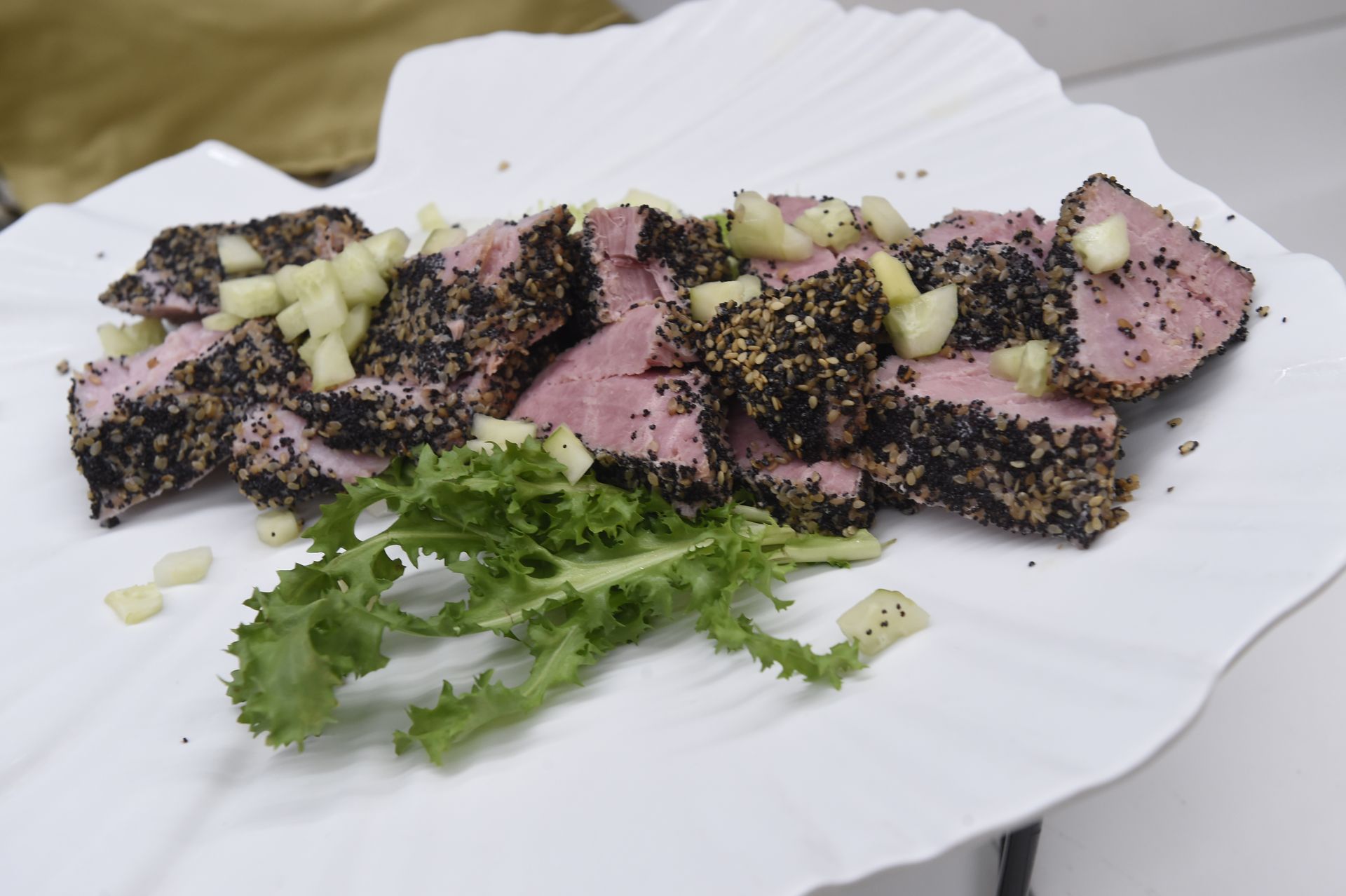 Un piatto bianco condito con carne e lattuga su un tavolo